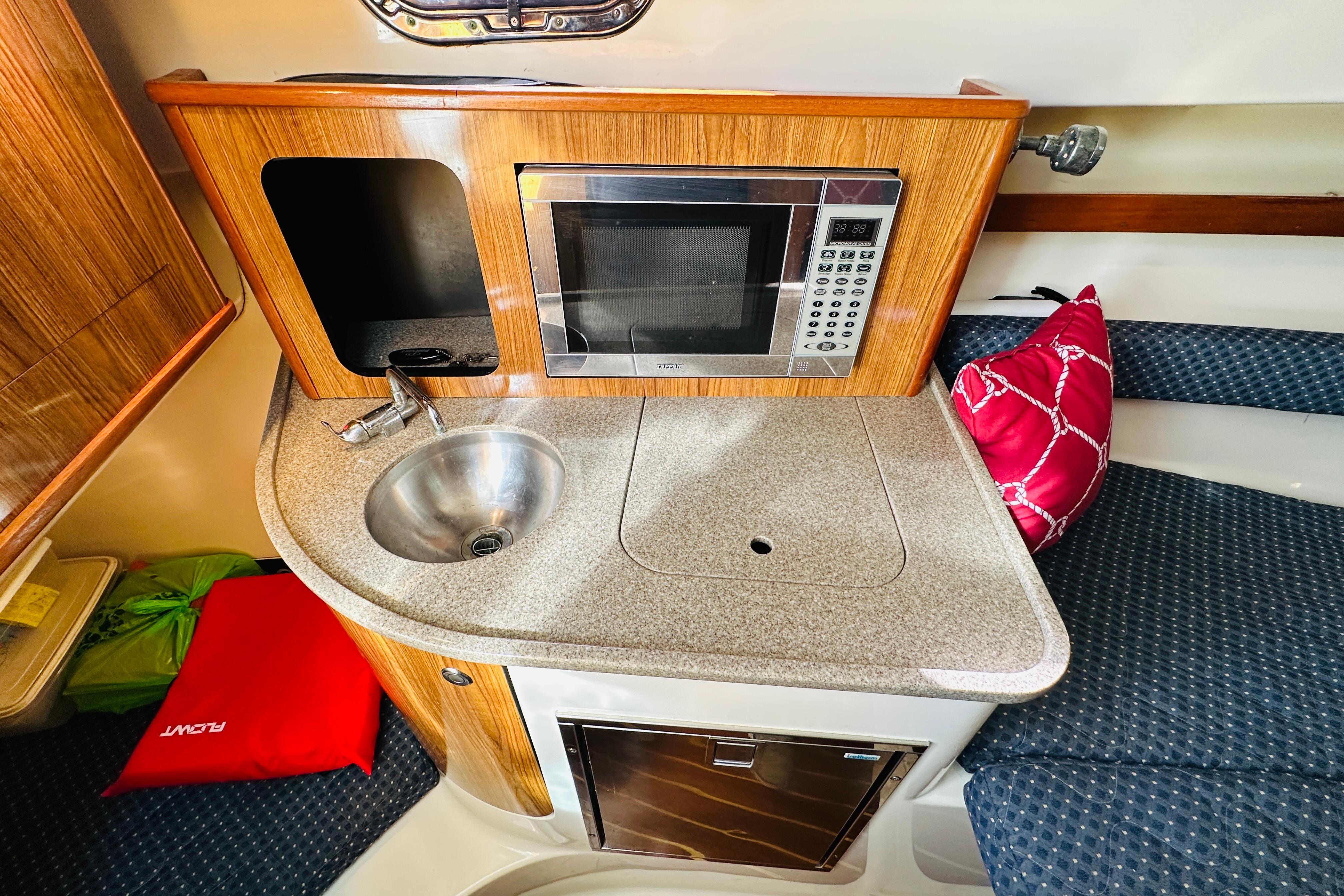 2007 Pursuit OS 285 Offshore boat interior with kitchenette, sink, and microwave.