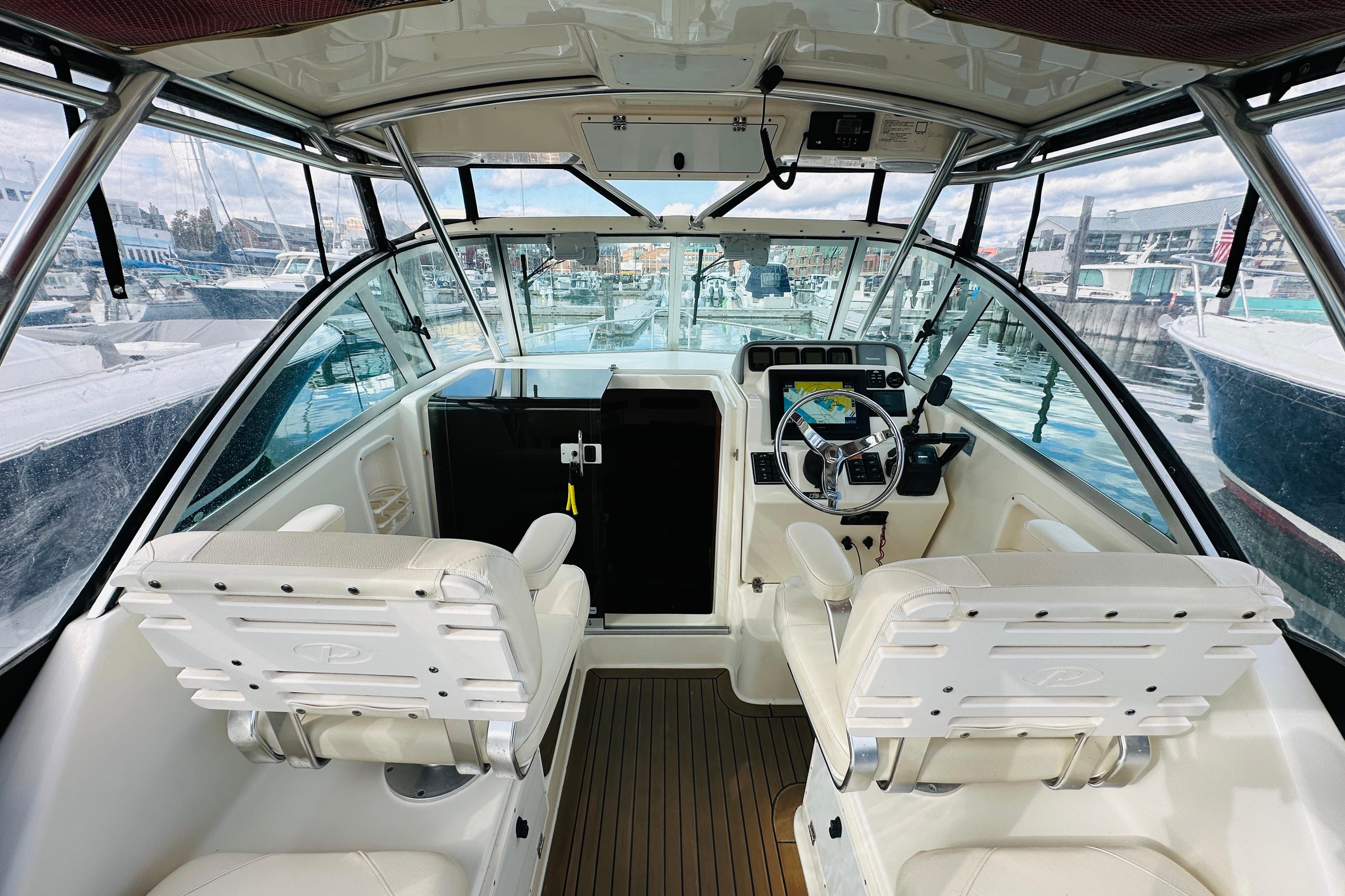 2007 Pursuit OS 285 Offshore boat interior with helm and seating at marina.
