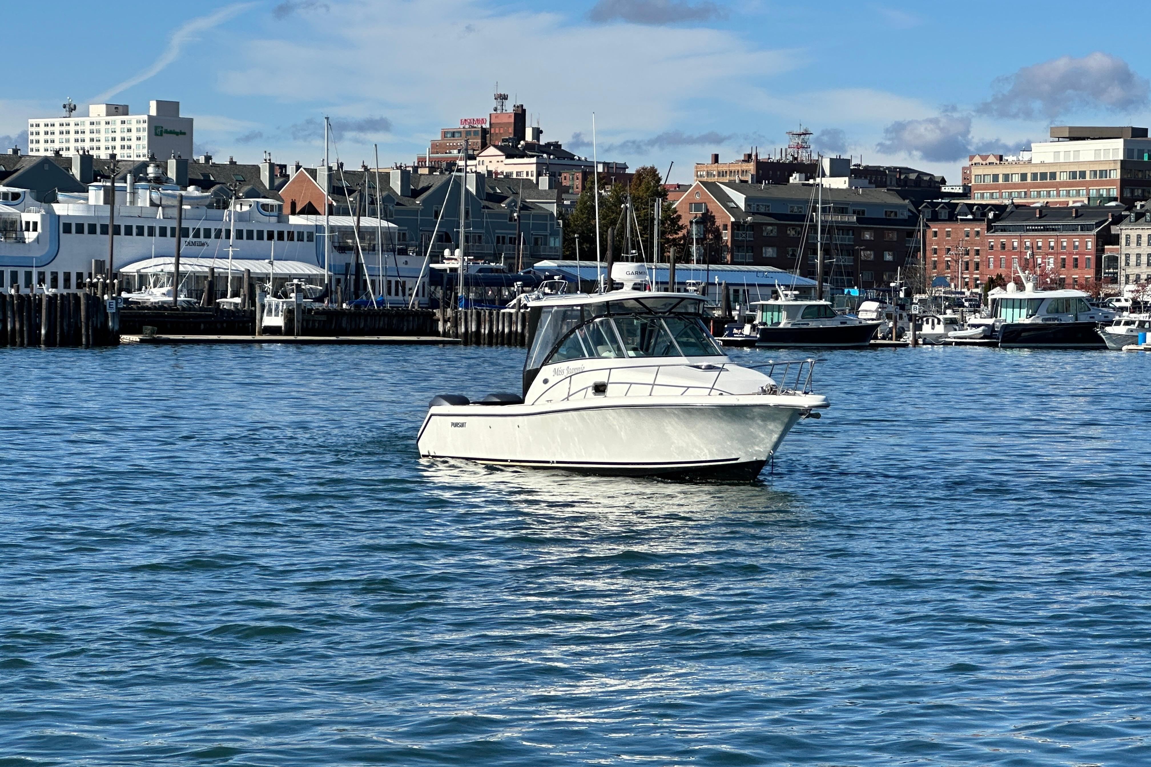 2007 Pursuit OS 285 Offshore boat on water with cityscape background.