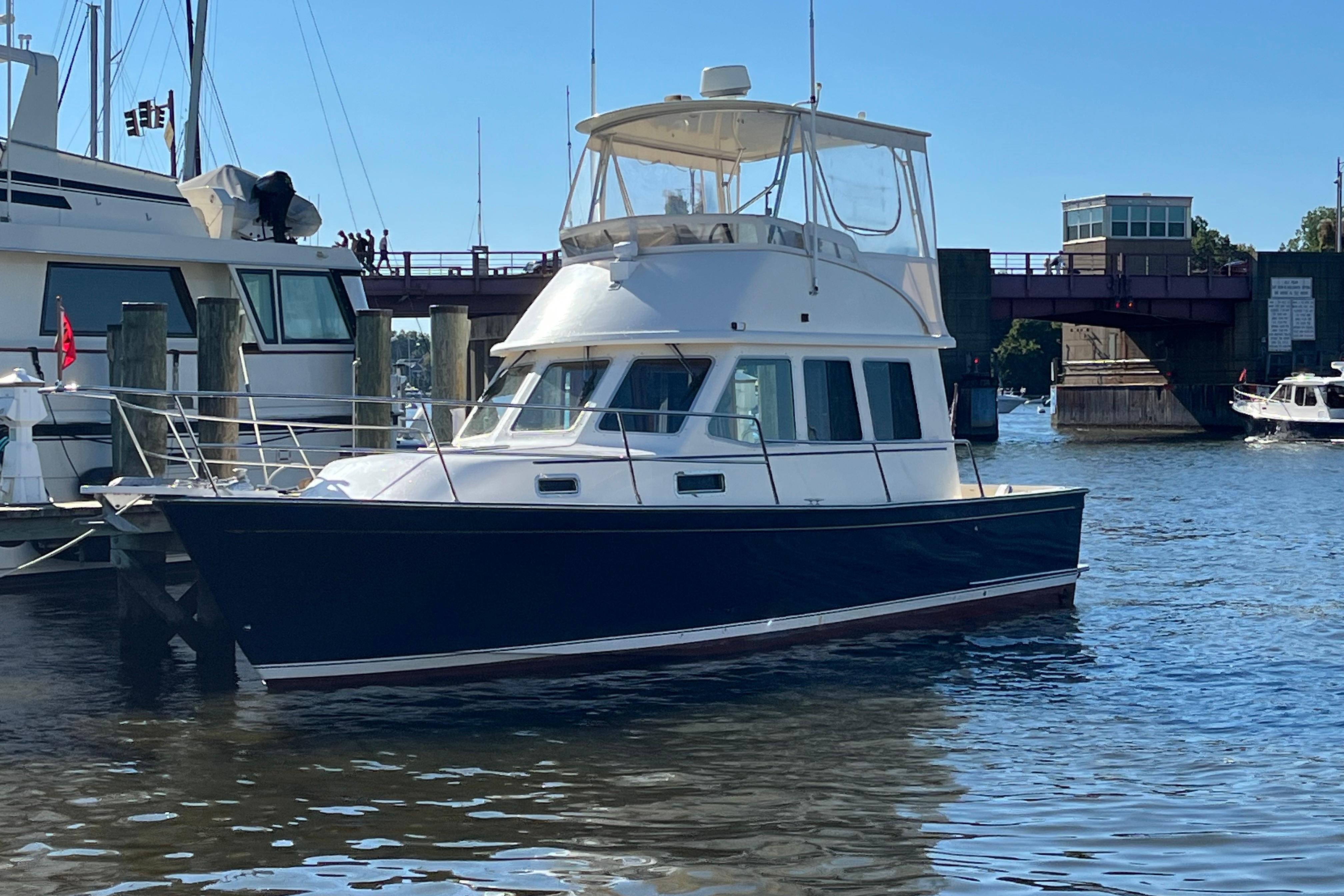 2006 Sabre 36 Flybridge Sedan docked in a marina, clear blue sky.