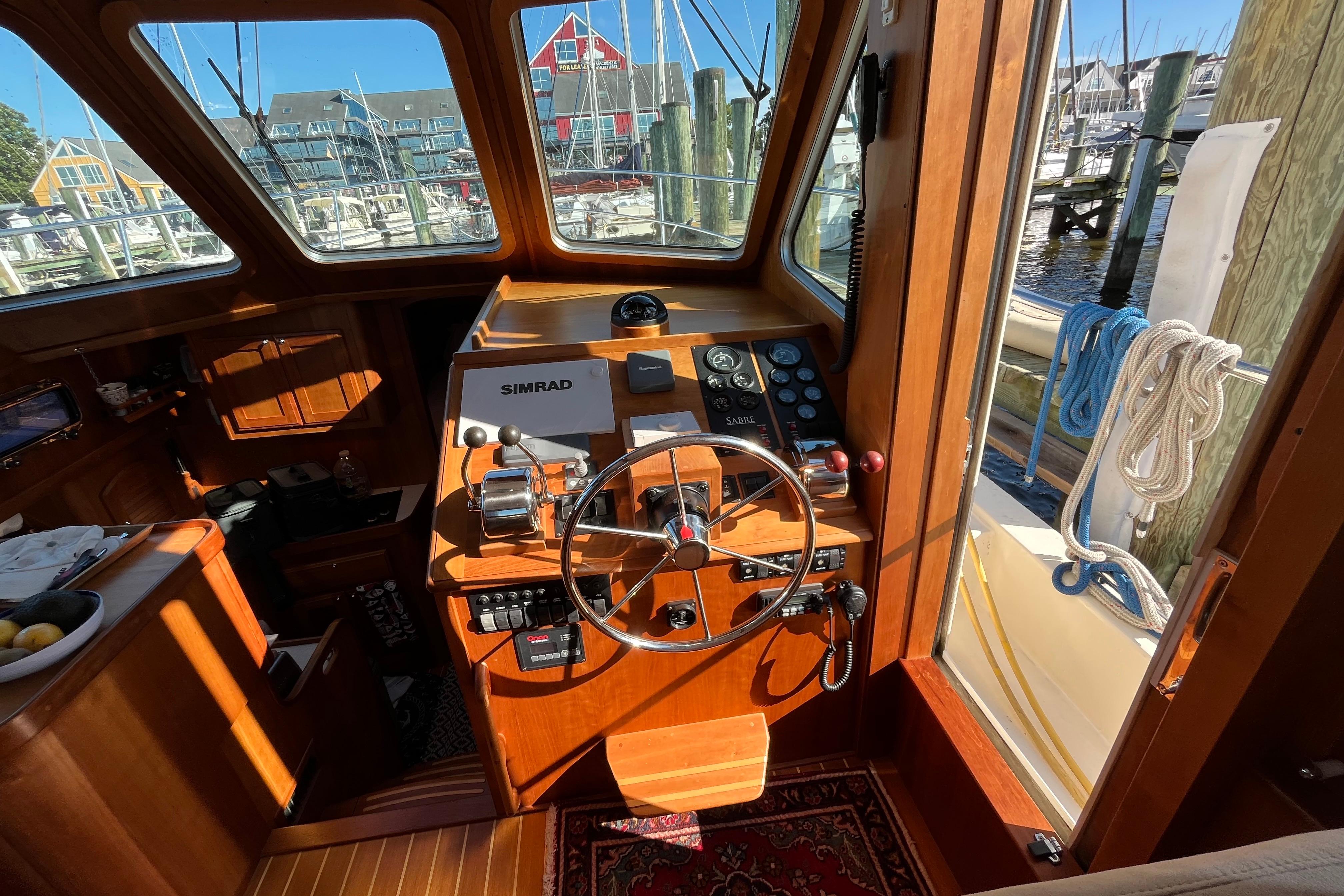 Interior view of 2006 Sabre 36 Flybridge Sedan helm with wooden finish and navigation equipment.