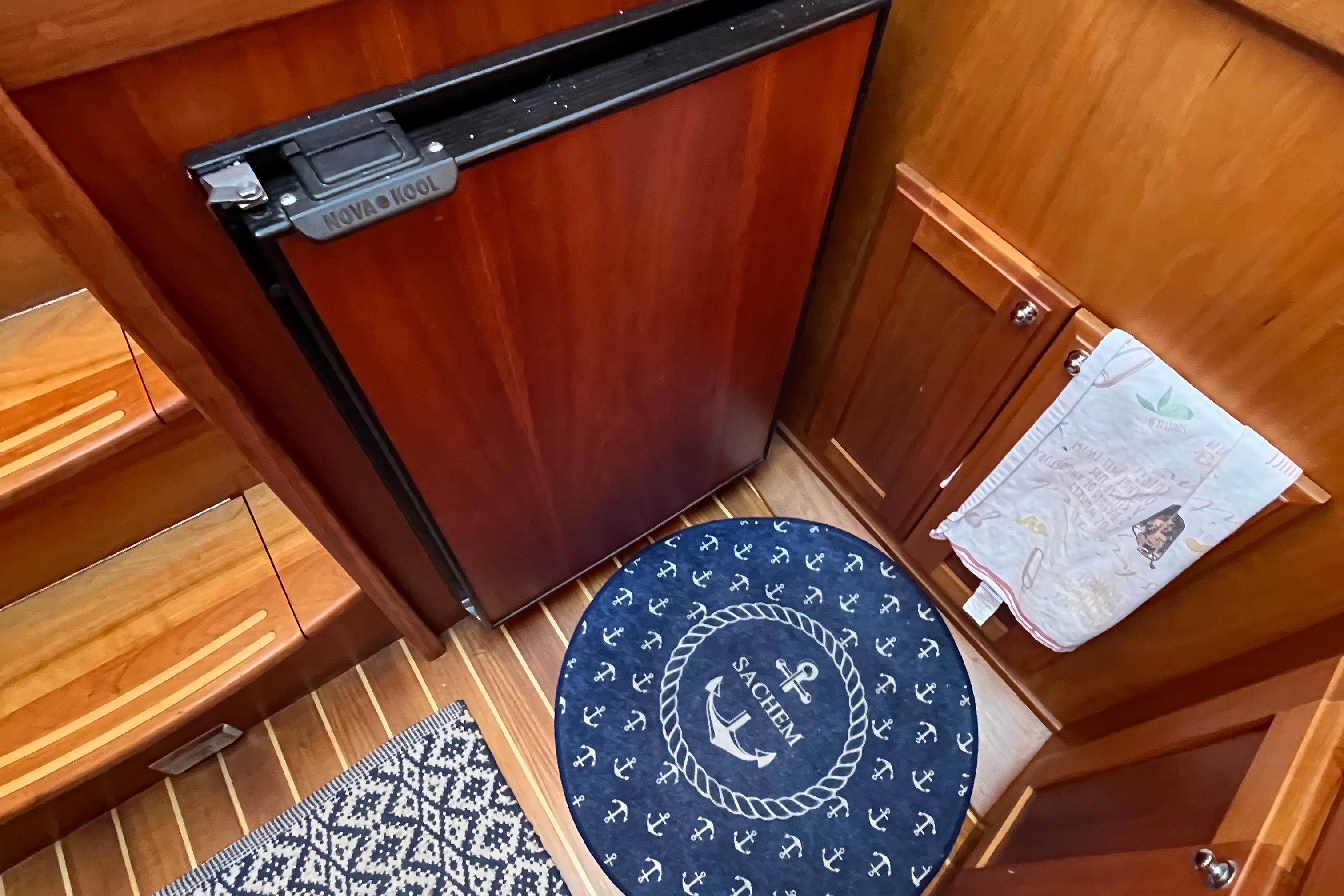 Interior of 2006 Sabre 36 Flybridge Sedan with wood finish and nautical-themed rug.