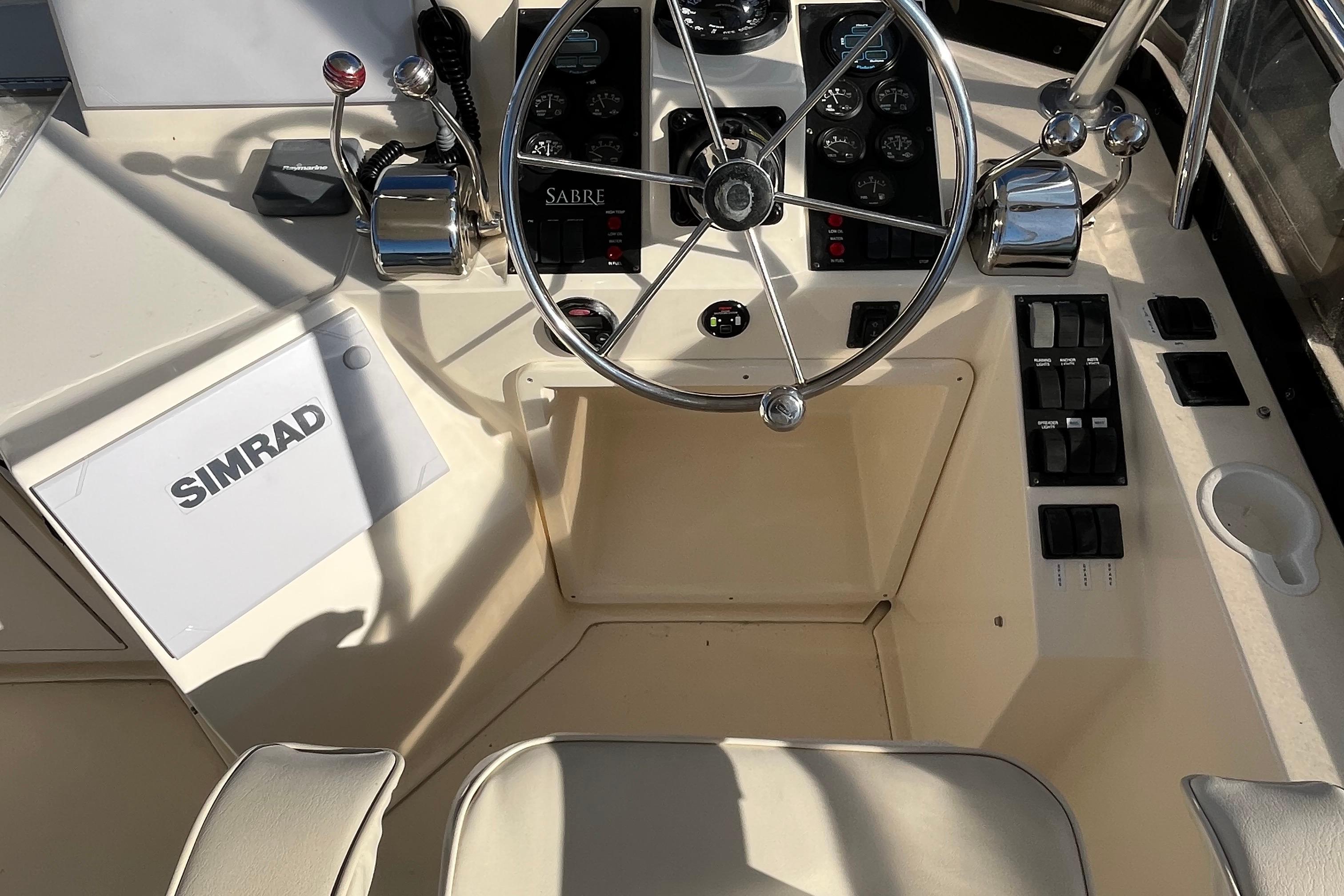 2006 Sabre 36 Flybridge Sedan helm with steering wheel, controls, and Simrad equipment.