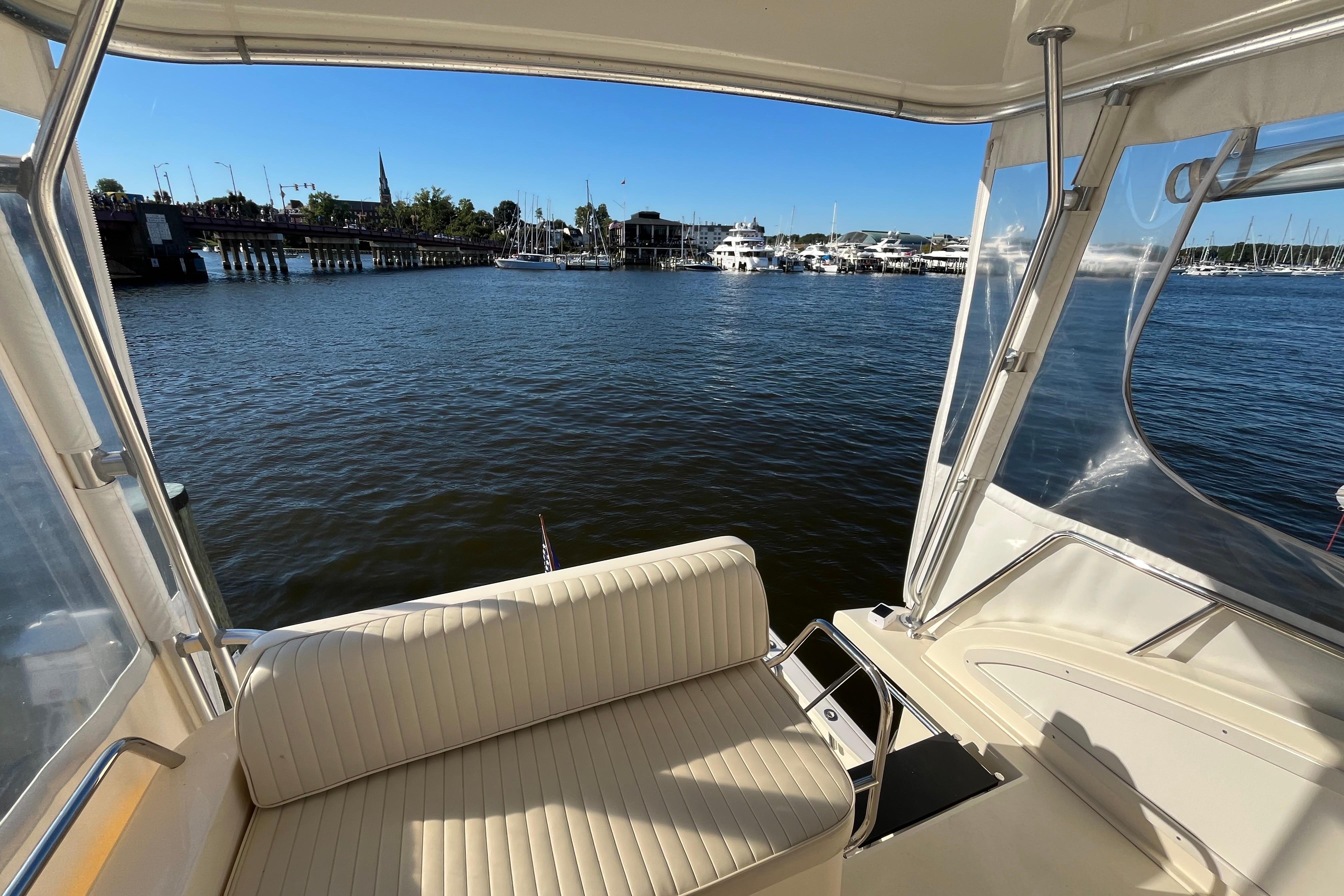 2006 Sabre 36 Flybridge Sedan interior with marina view, featuring comfortable seating and clear skies.