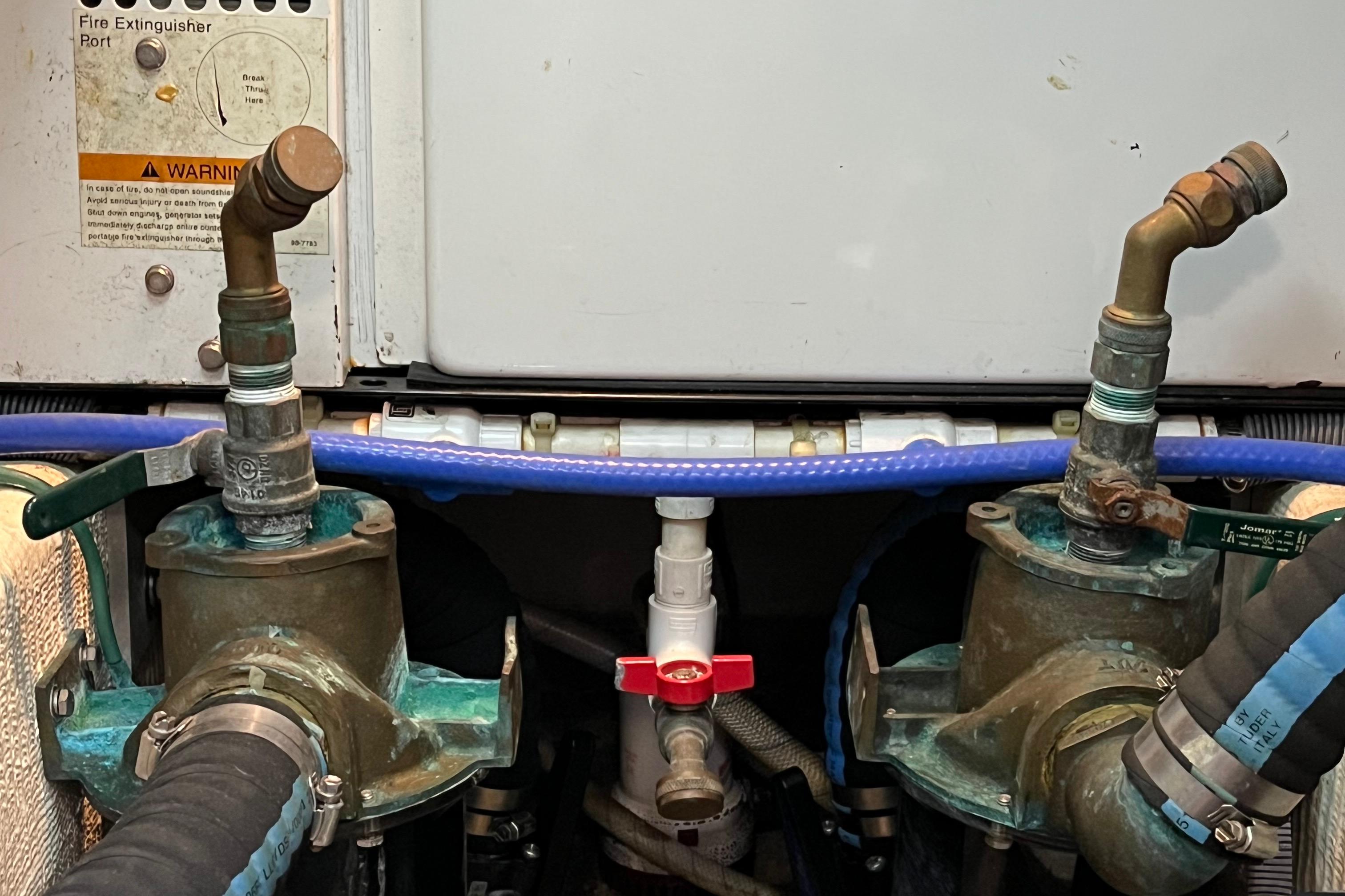 Engine room of 2006 Sabre 36 Flybridge Sedan with fire extinguisher port and plumbing components.