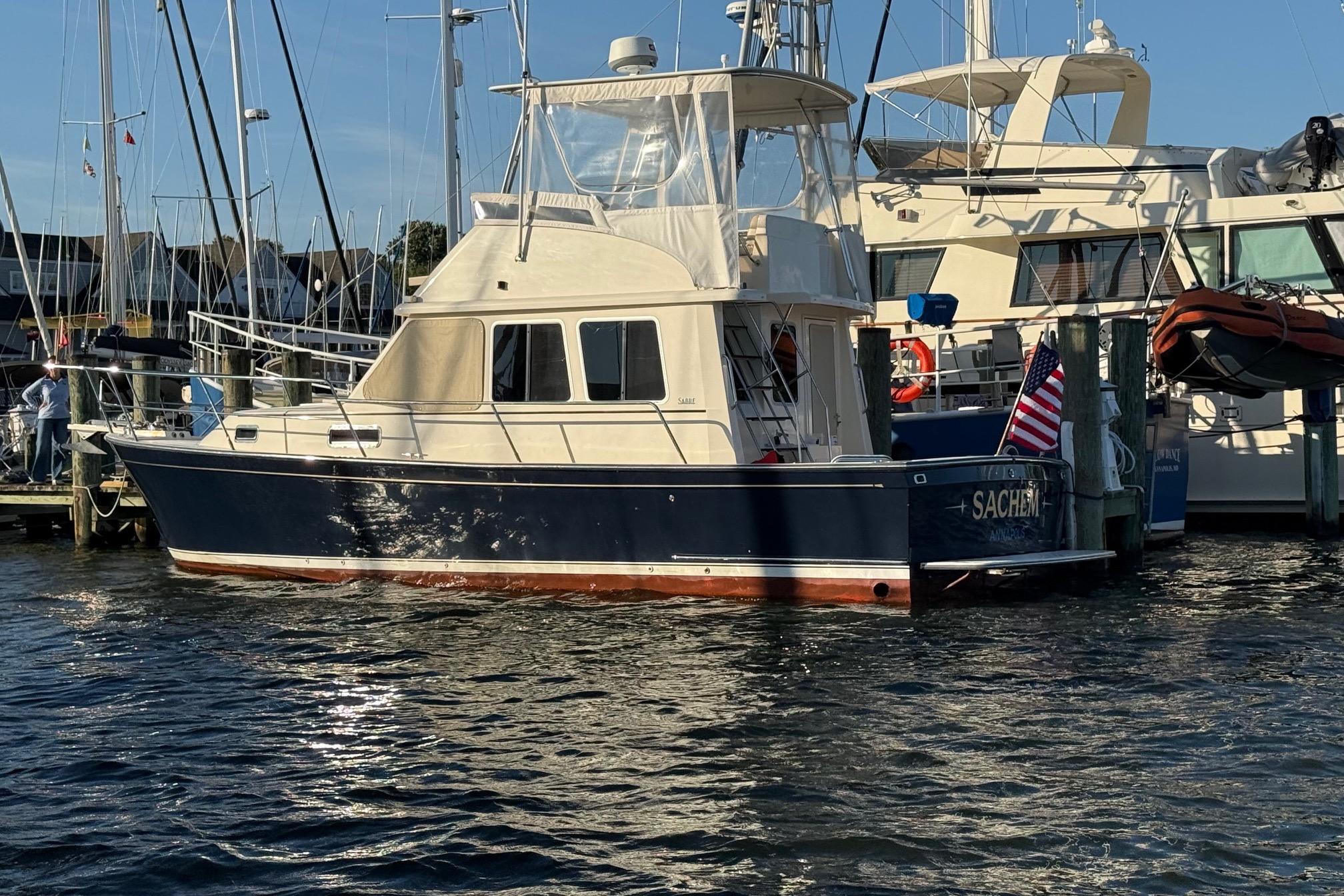 2006 Sabre 36 Flybridge Sedan docked at marina, displaying American flag.