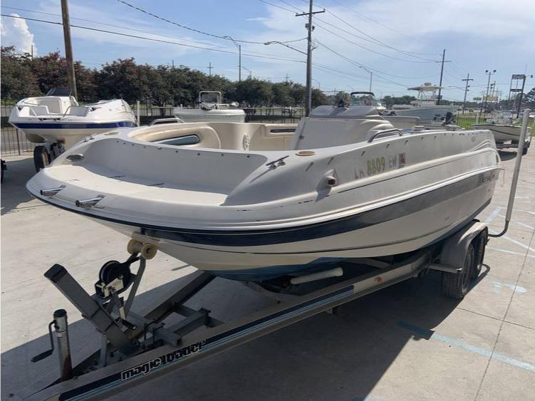 1997 Regal 200 DESTINY boat on a trailer in a parking lot.