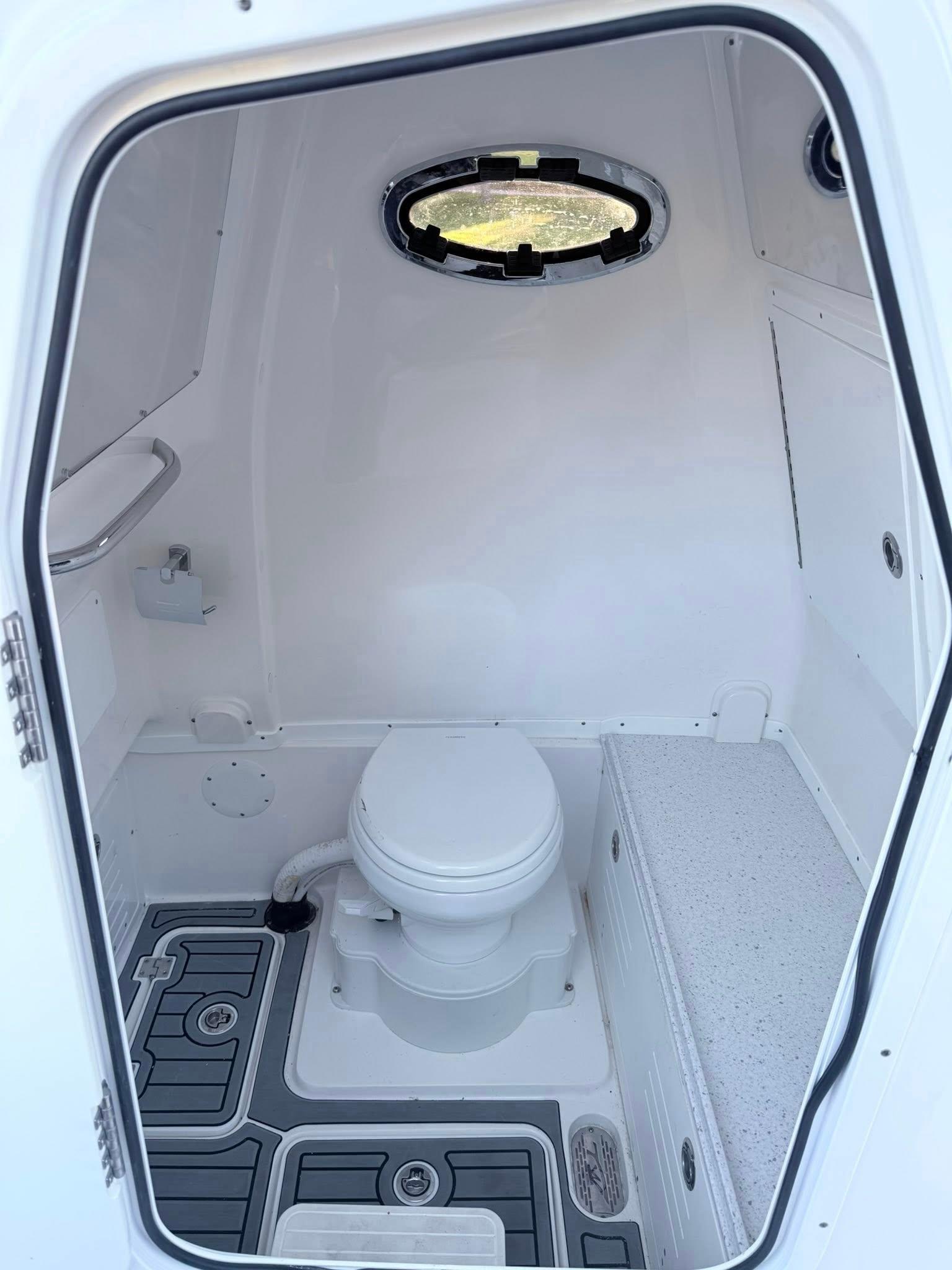 Tidewater-3100 Carolina Bay 2025 -FL-US-2025 Tidewater 3100 Carolina Bay boat interior with compact marine toilet and porthole.-9803417 | Thumbnail