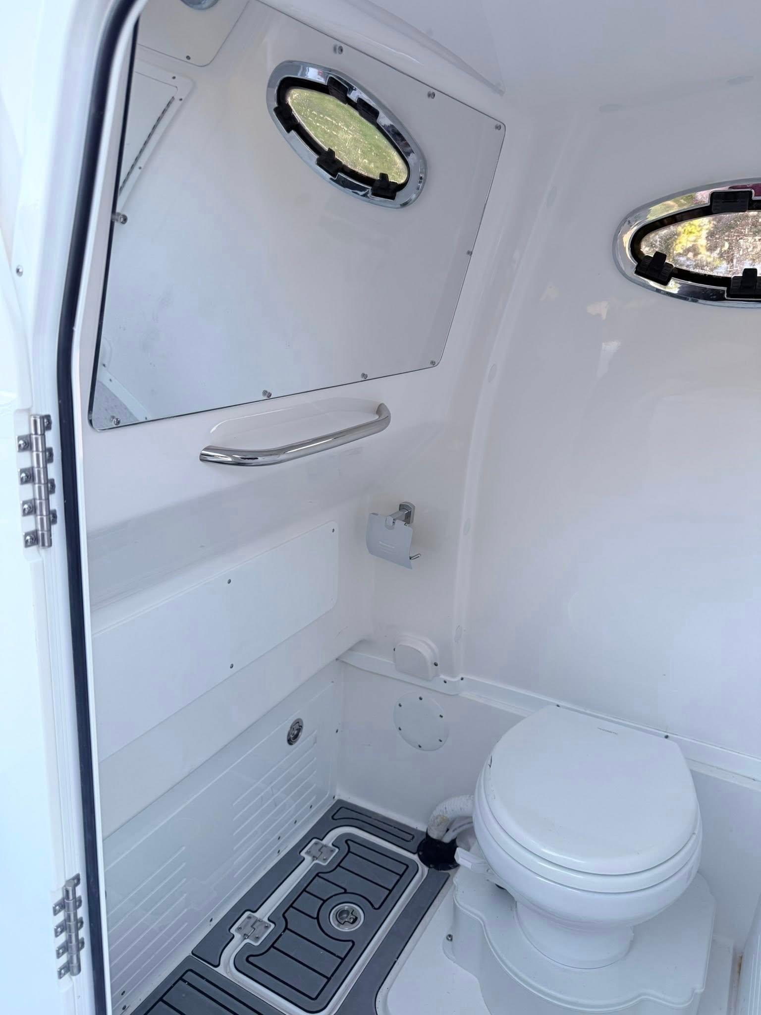Tidewater-3100 Carolina Bay 2025 -FL-US-2025 Tidewater 3100 Carolina Bay boat interior with modern marine toilet and portholes.-9803417 | Thumbnail
