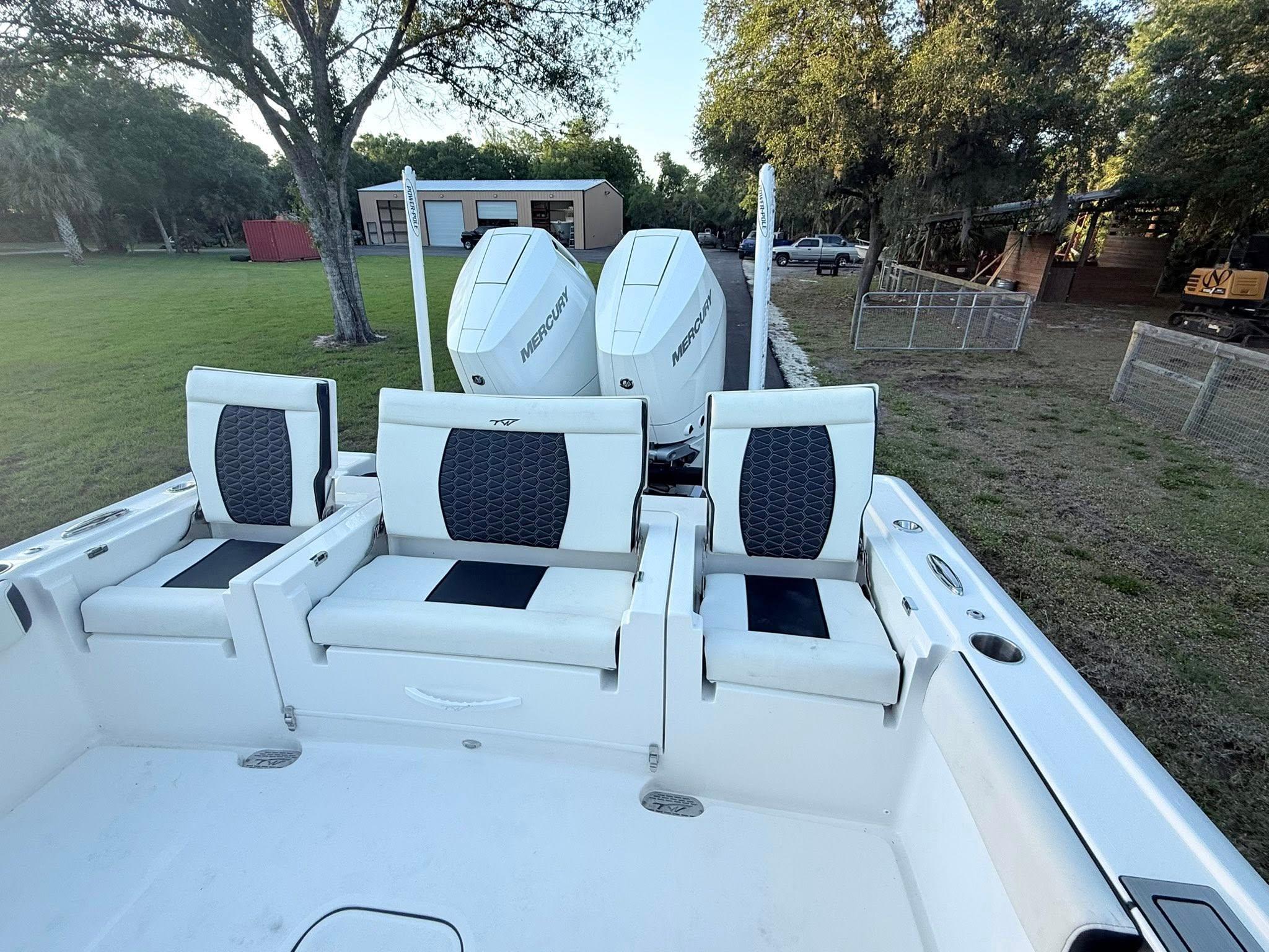Tidewater-3100 Carolina Bay 2025 -FL-US-2025 Tidewater 3100 Carolina Bay boat with dual engines and seating, parked on grass.-9803417 | Thumbnail