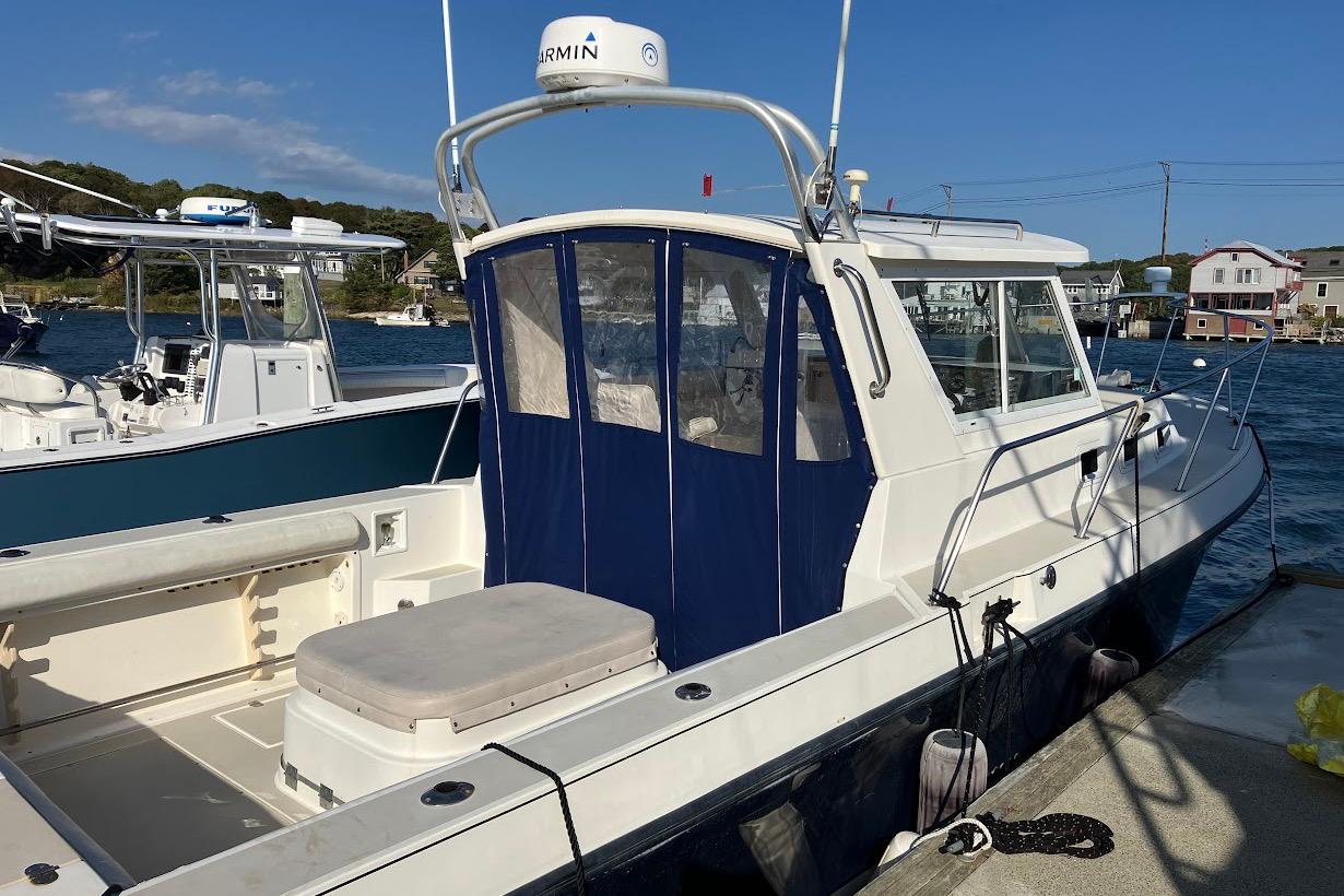 2000 Albin 28 Tournament boat docked, featuring a blue canopy and white exterior.