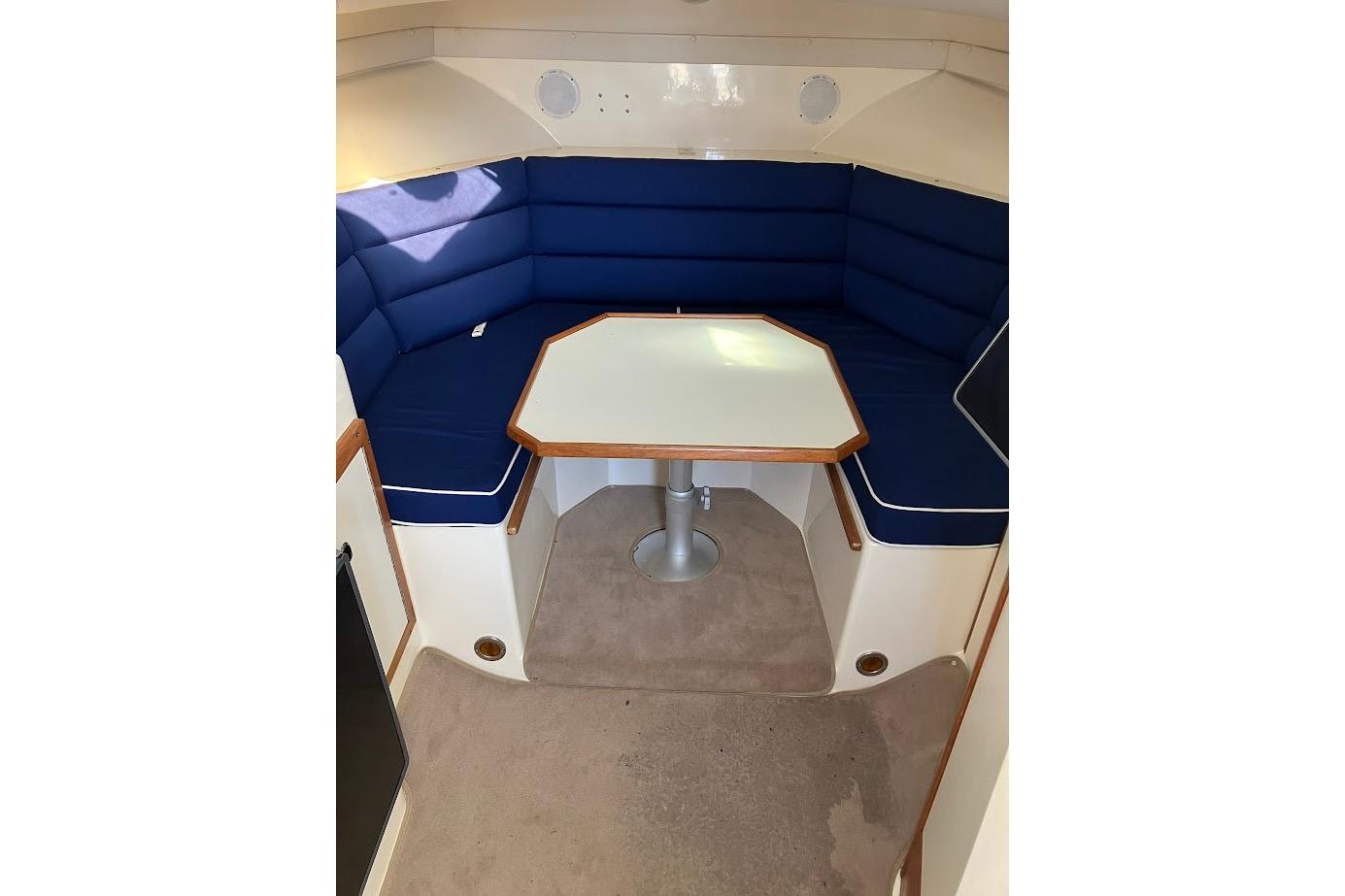 2000 Albin 28 Tournament cabin interior with blue seating and table.