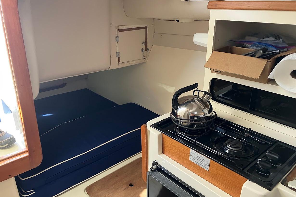 Interior of 2000 Albin 28 Tournament boat with kitchenette and sleeping area.