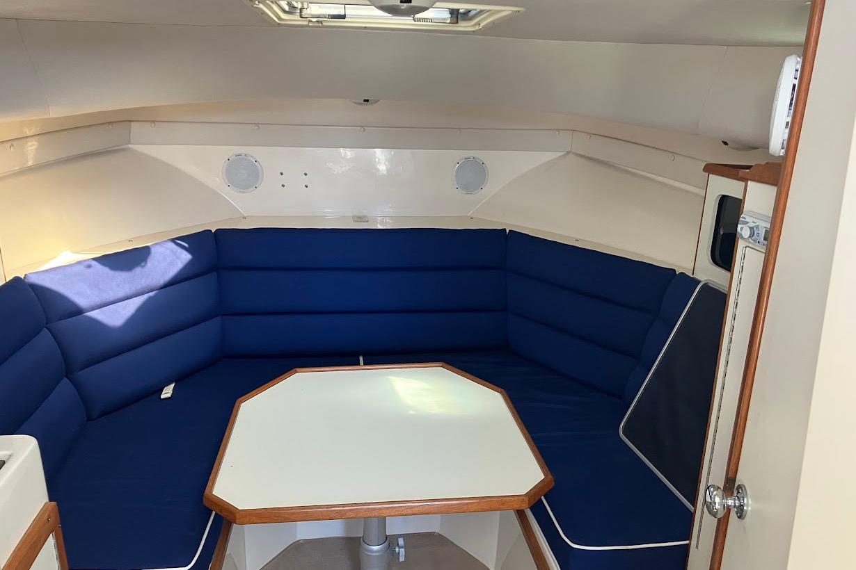 Interior of 2000 Albin 28 Tournament boat with blue cushioned seating and table.