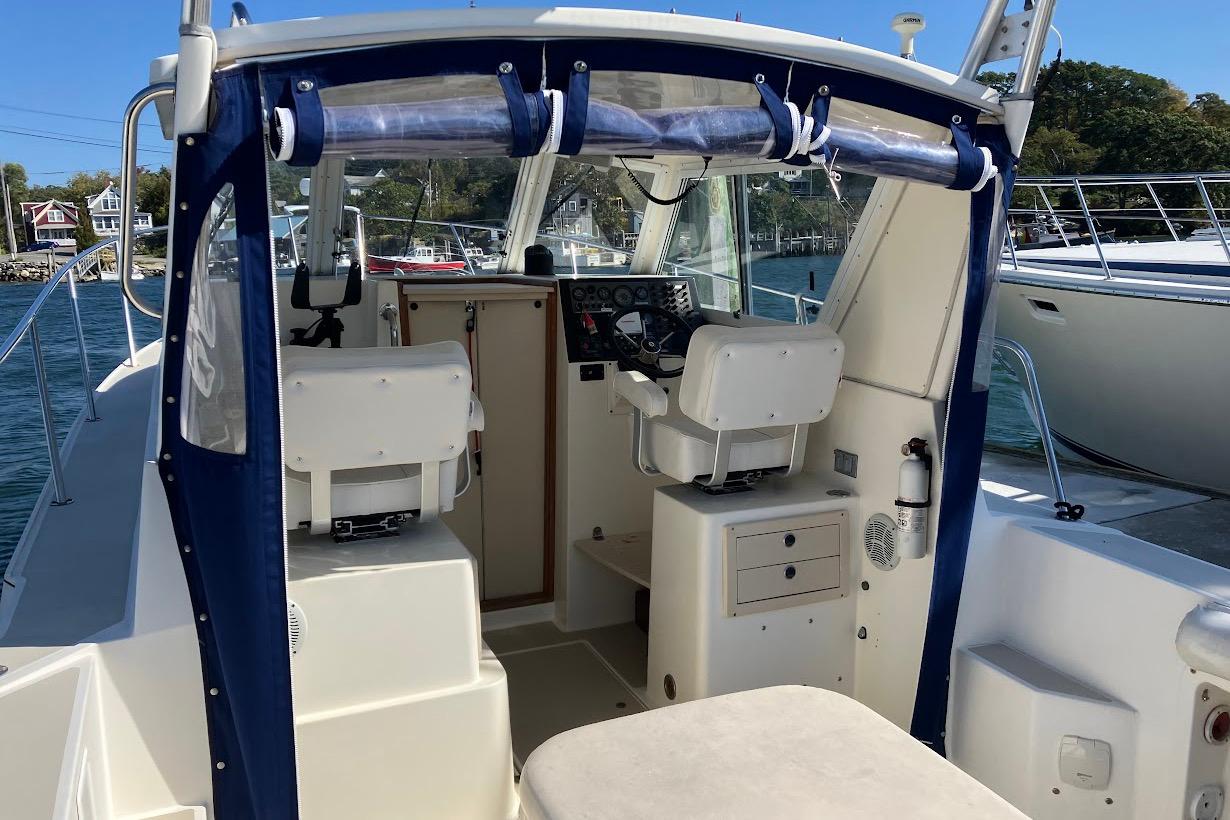 2000 Albin 28 Tournament boat interior with helm and seating, docked by the water.
