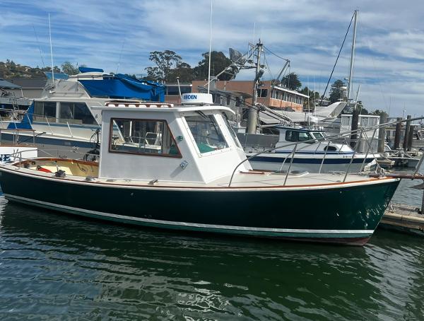 1974 Dyer 29' Sport Fisher boat docked at a marina under a cloudy sky.