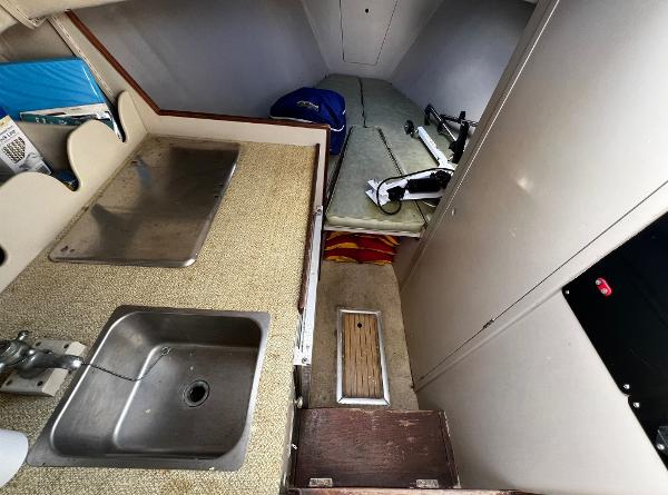 1974 Dyer 29' Sport Fisher interior with sink, counter, and sleeping area.