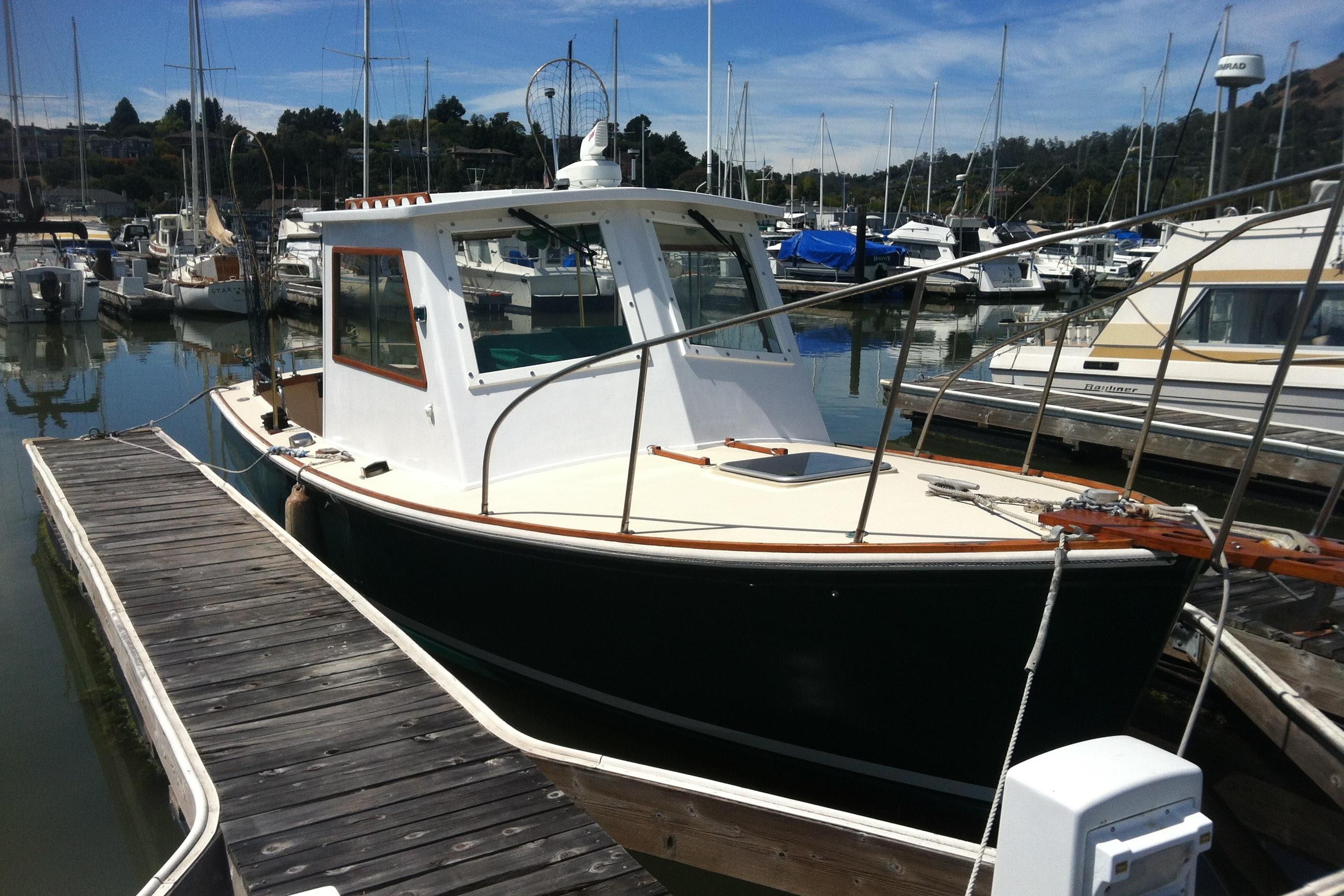 1974 Dyer 29' Sport Fisher boat docked in a marina, surrounded by other vessels.