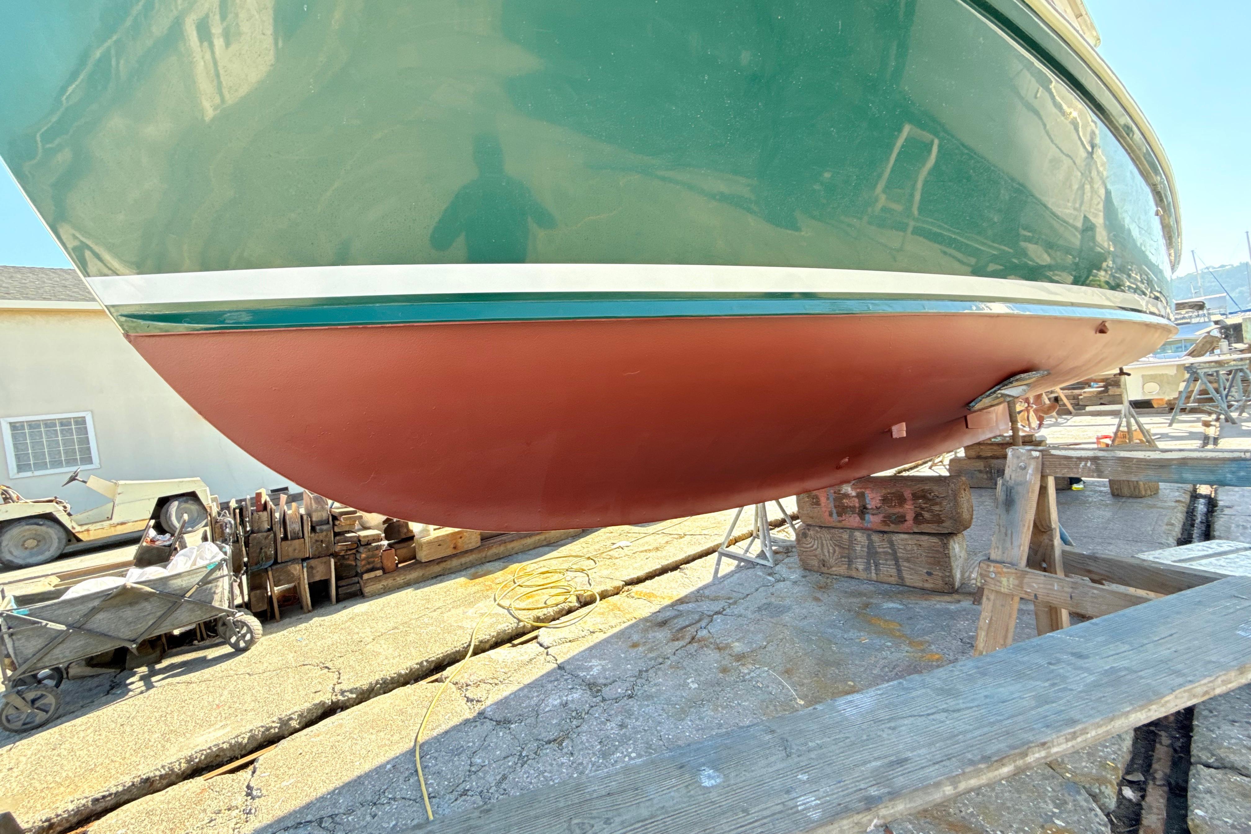 1974 Dyer 29' Sport Fisher boat on dry dock, green and red hull visible.