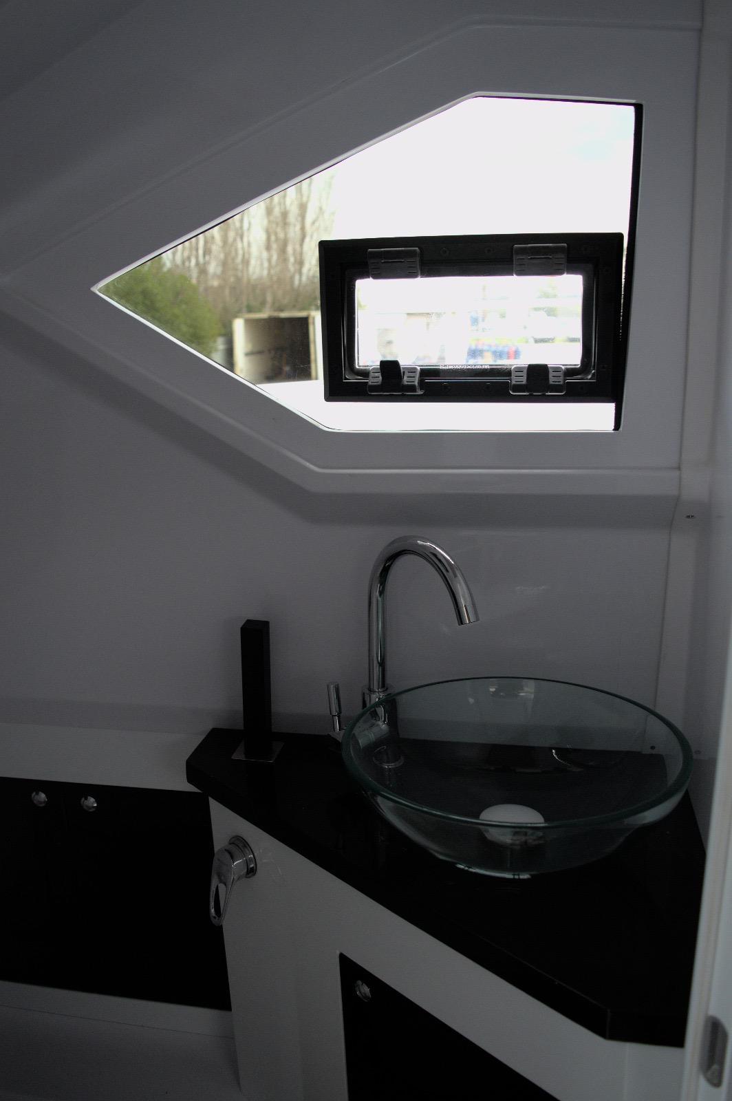 DNA-46 2026 -FL-US-Modern bathroom interior in DNA 46, 2025 model, featuring glass sink and geometric window.-9703461 | Thumbnail