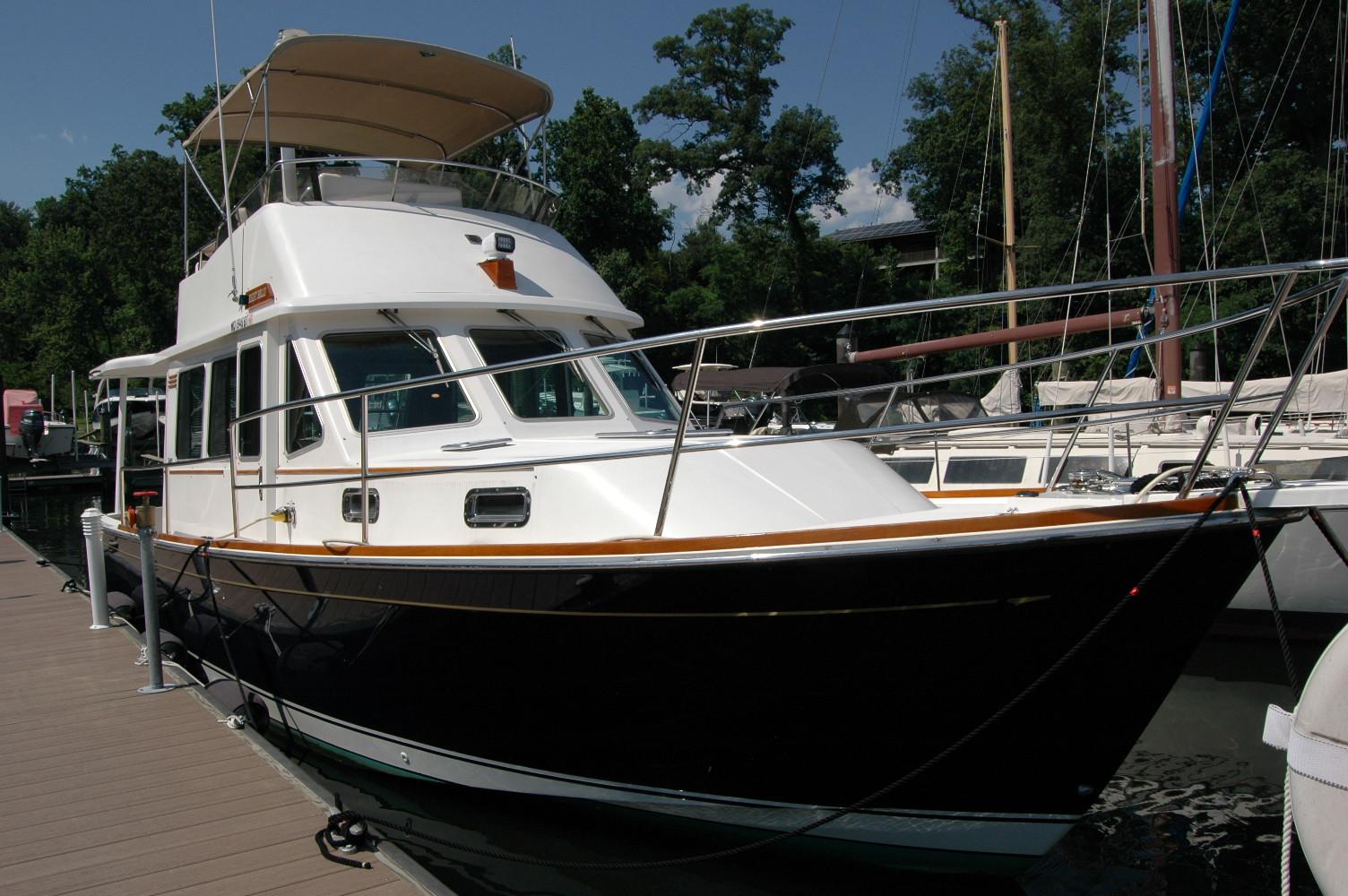 2006 Sabre 36 Flybridge Sedan docked at marina, surrounded by trees and other boats.