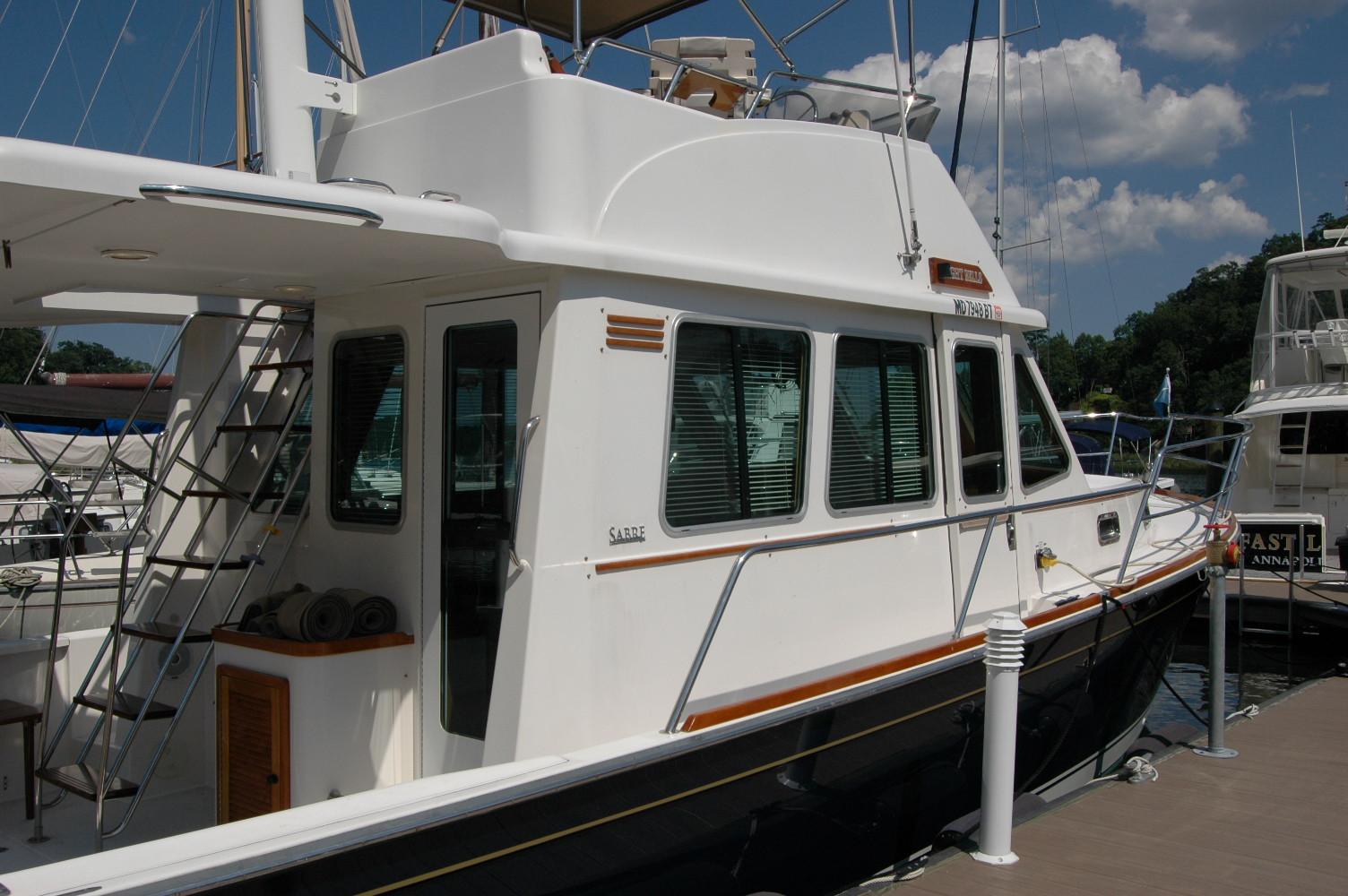 2006 Sabre 36 Flybridge Sedan docked at marina under clear sky.