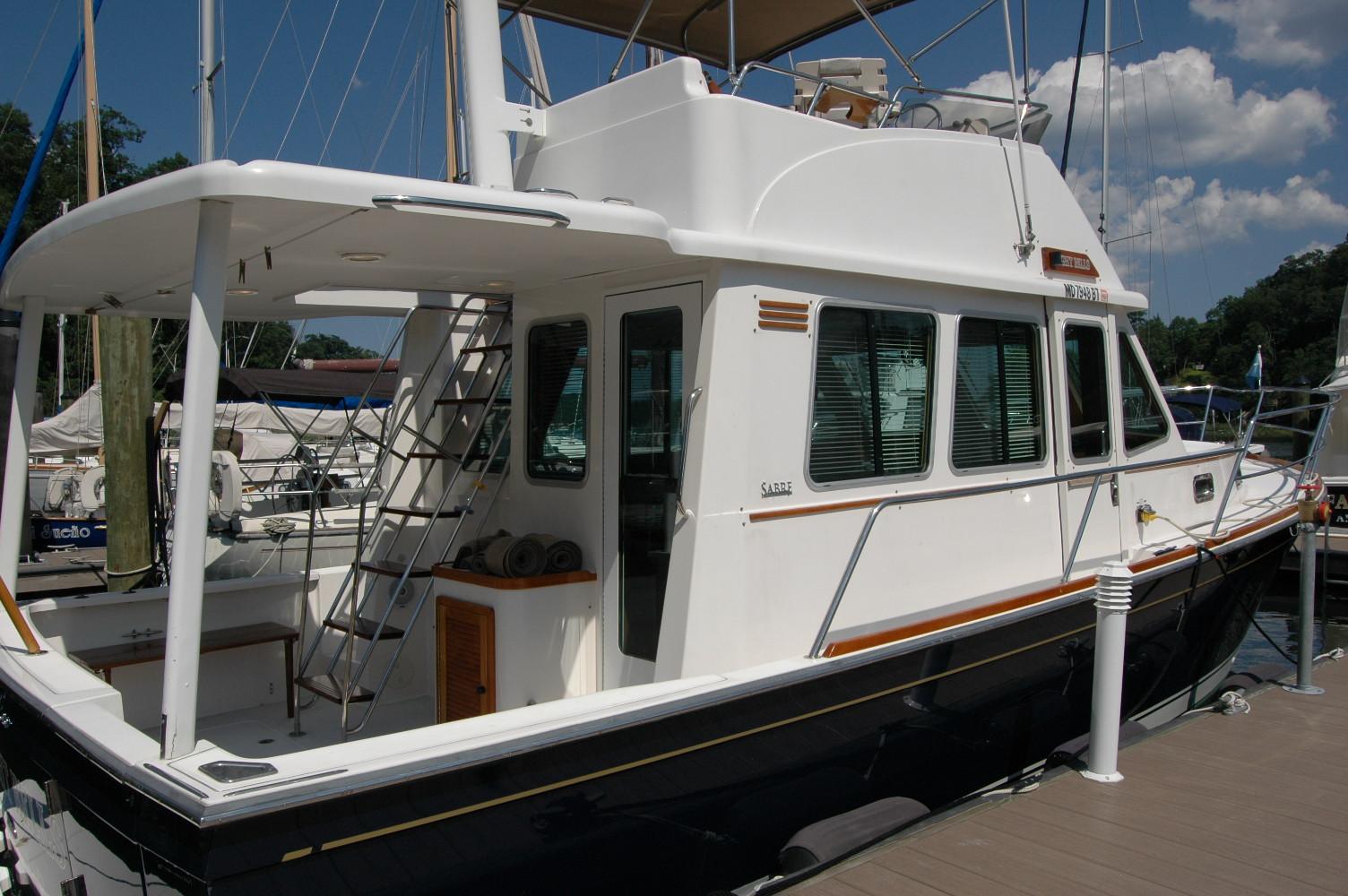 2006 Sabre 36 Flybridge Sedan docked at marina, side view.
