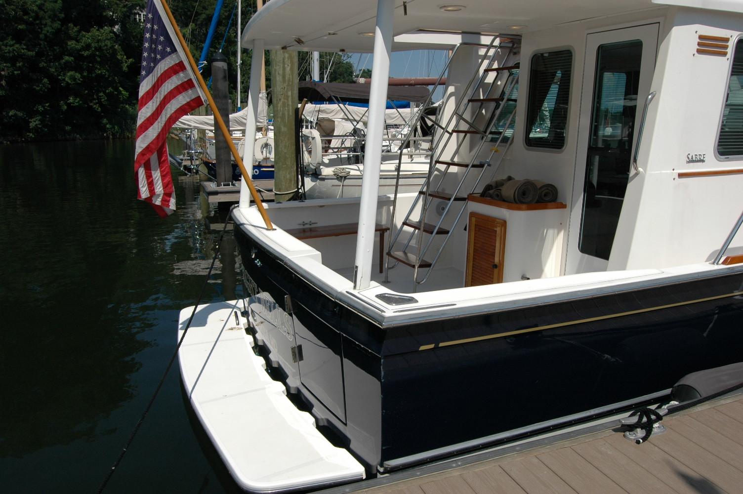 2006 Sabre 36 Flybridge Sedan docked, featuring American flag and sleek design.