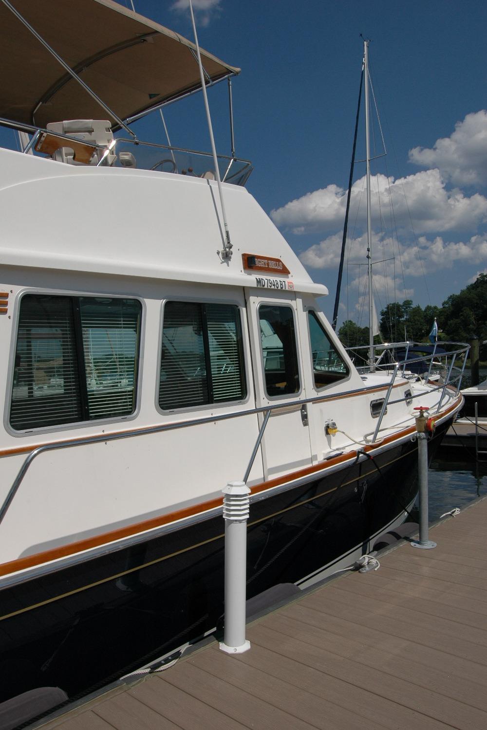 2006 Sabre 36 Flybridge Sedan docked at marina under clear blue sky.
