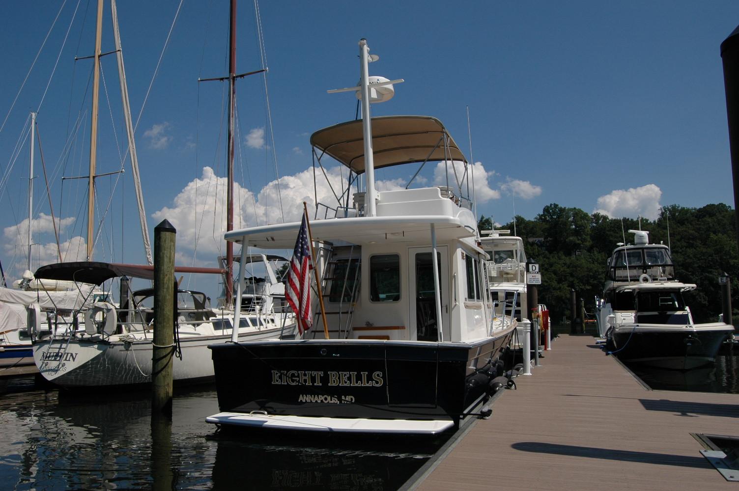 2006 Sabre 36 Flybridge Sedan docked at marina, clear sky, American flag displayed.