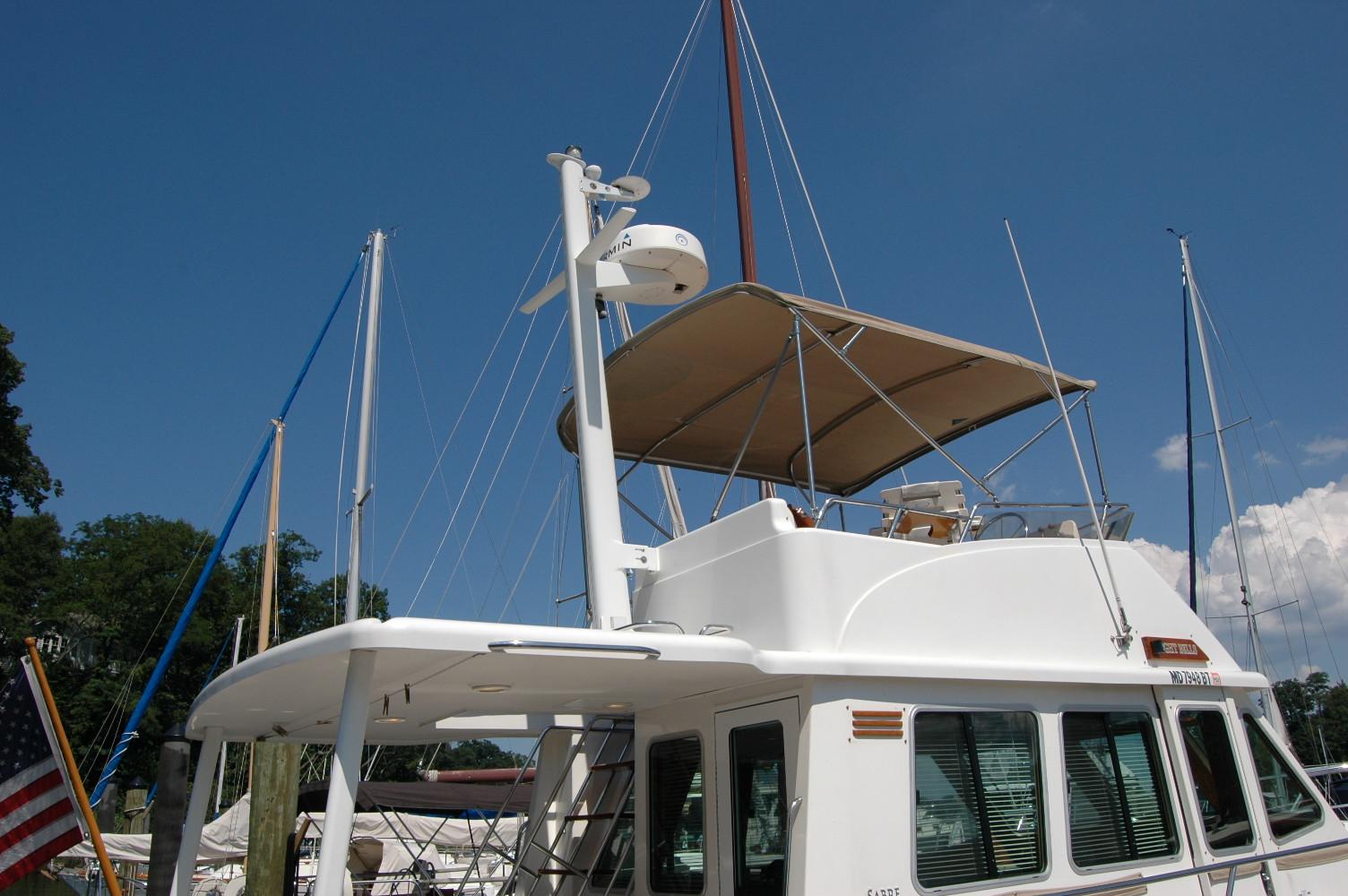 2006 Sabre 36 Flybridge Sedan yacht with canopy, docked under clear blue sky.
