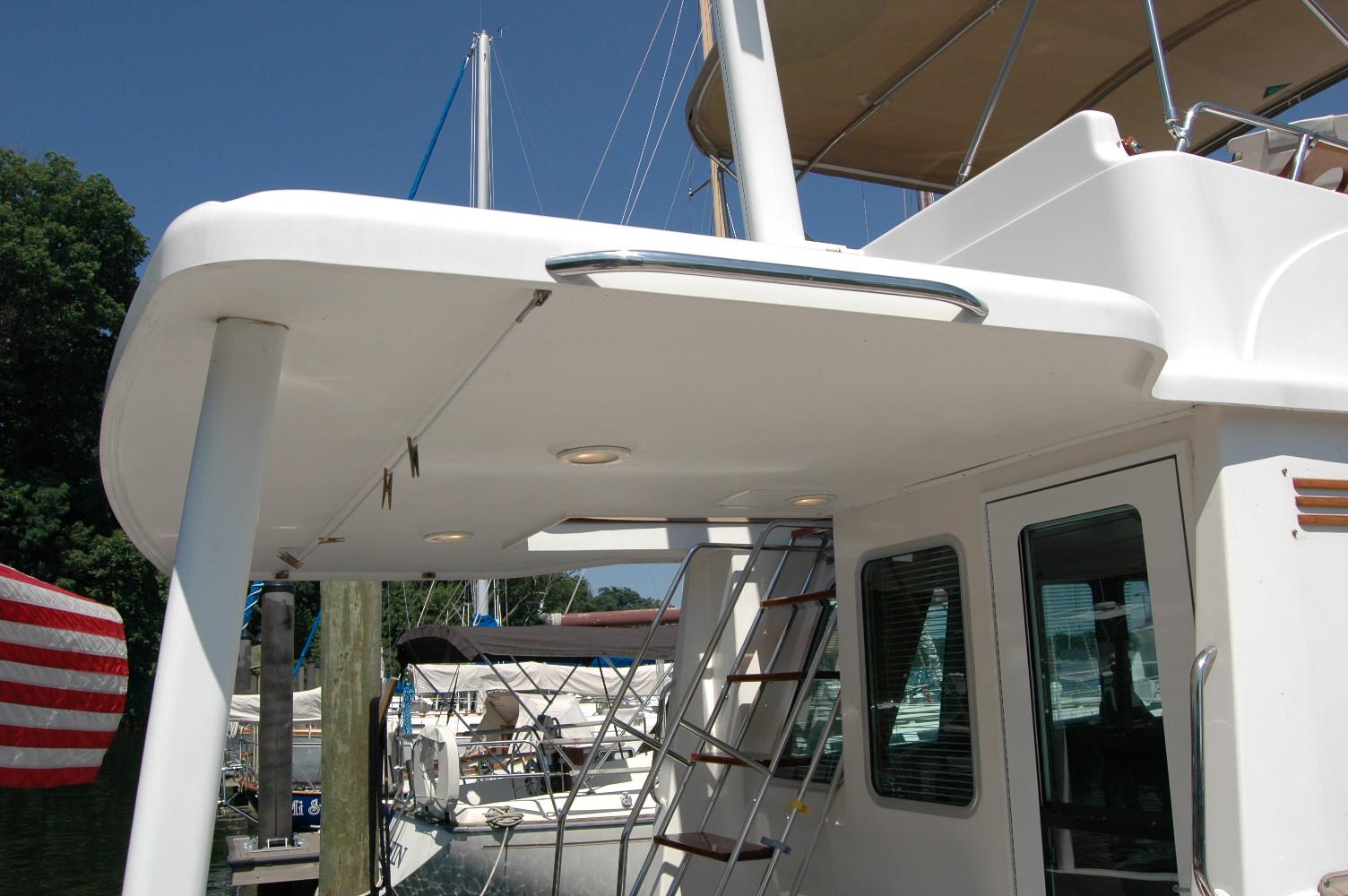 2006 Sabre 36 Flybridge Sedan yacht with ladder and shaded deck area.