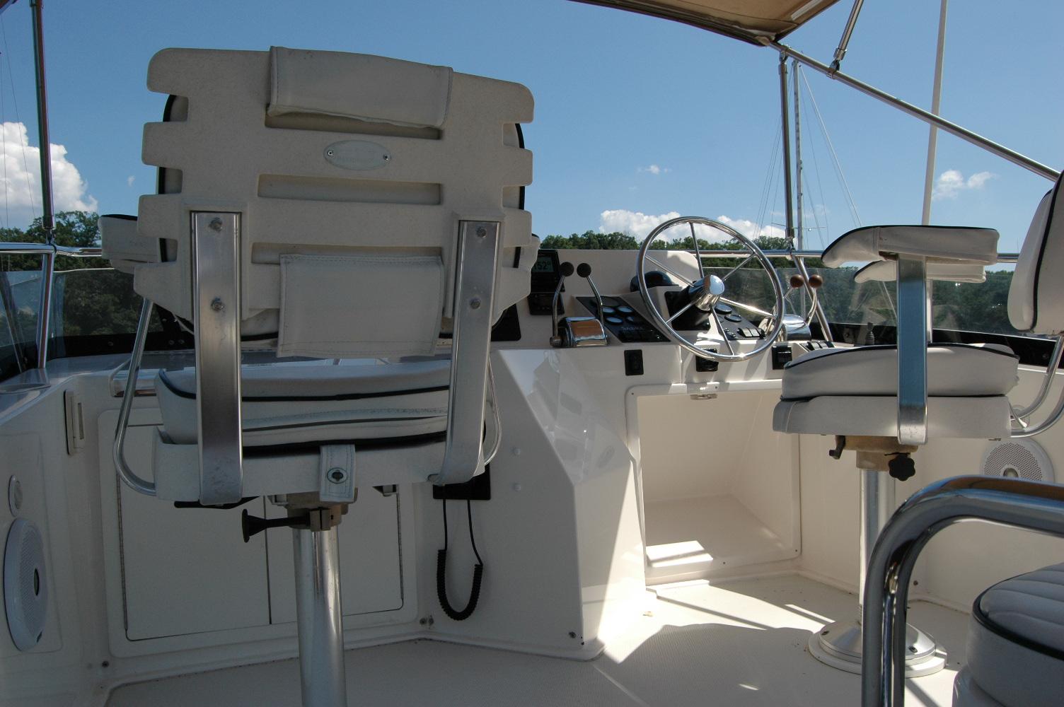 2006 Sabre 36 Flybridge Sedan helm with dual captain chairs and steering wheel.