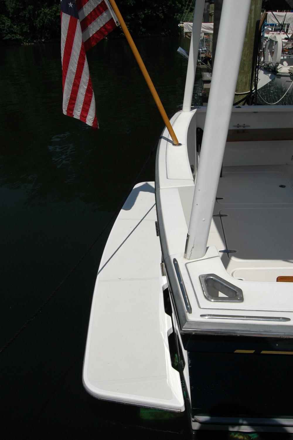 2006 Sabre 36 Flybridge Sedan boat with American flag, docked on calm water.