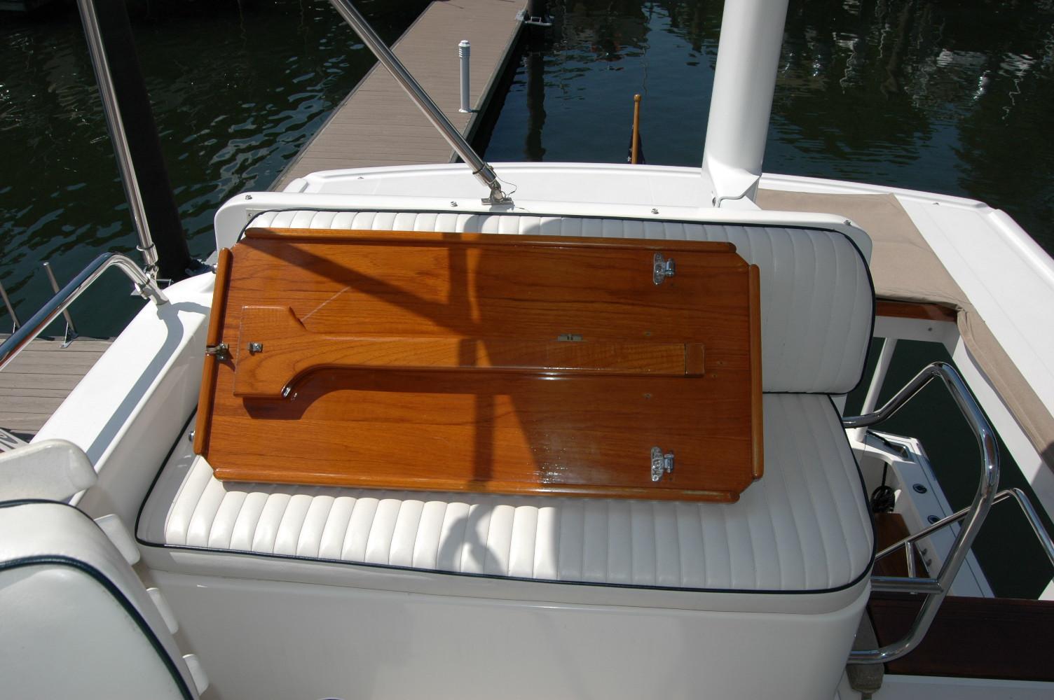 2006 Sabre 36 Flybridge Sedan with wooden table on white cushioned seating.