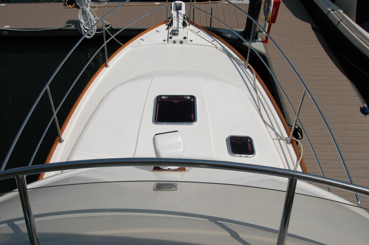 2006 Sabre 36 Flybridge Sedan boat deck with hatches and railing, docked at marina.