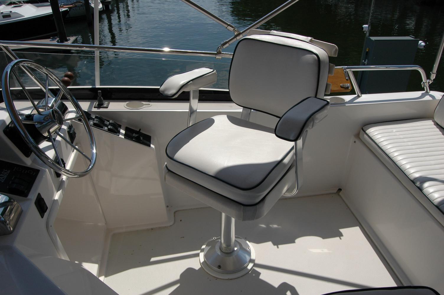 2006 Sabre 36 Flybridge Sedan helm with white captainu0027s chair and steering wheel.