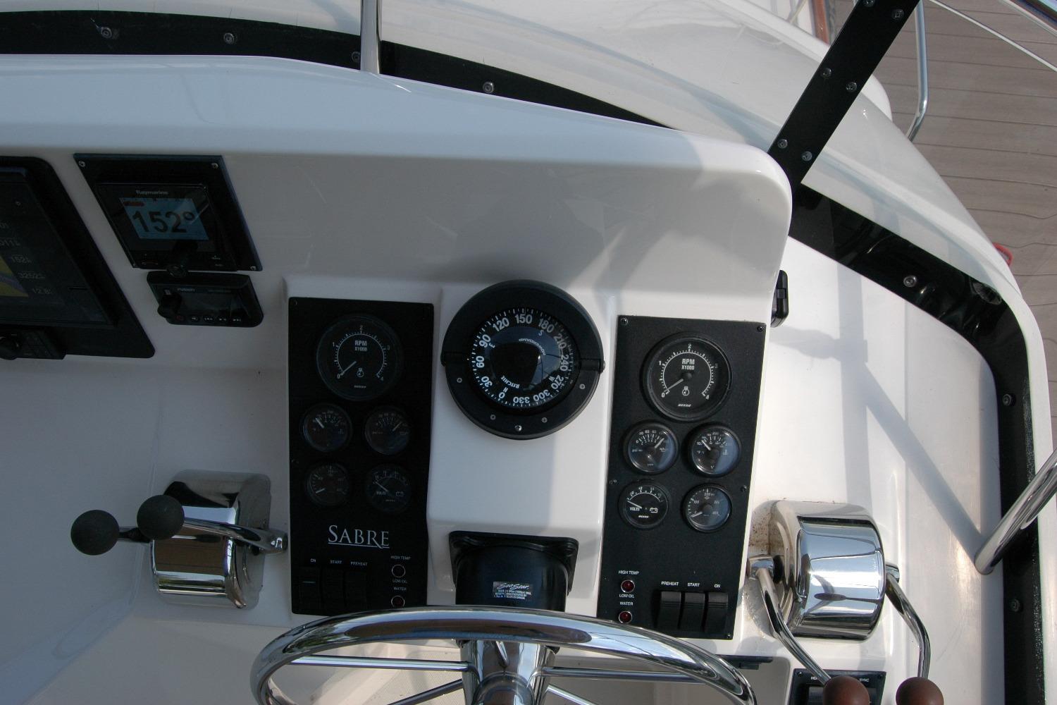 Control panel of 2006 Sabre 36 Flybridge Sedan with gauges and steering wheel.