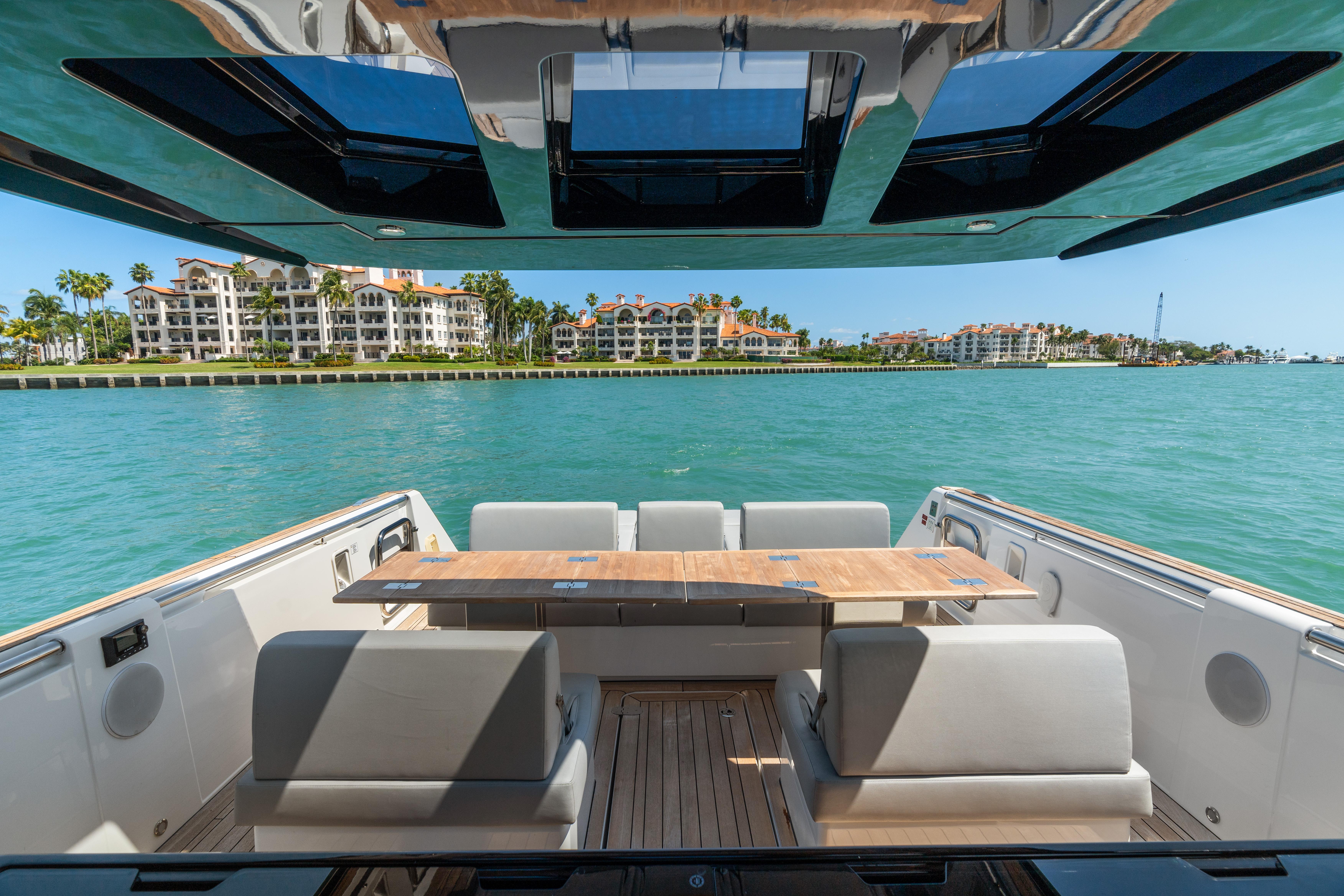 Fjord-44 Open 2022-HINJUICE FL-US-2022 Fjord 44 Open yacht with luxurious seating, overlooking waterfront buildings and clear blue water.-9860902 | Thumbnail