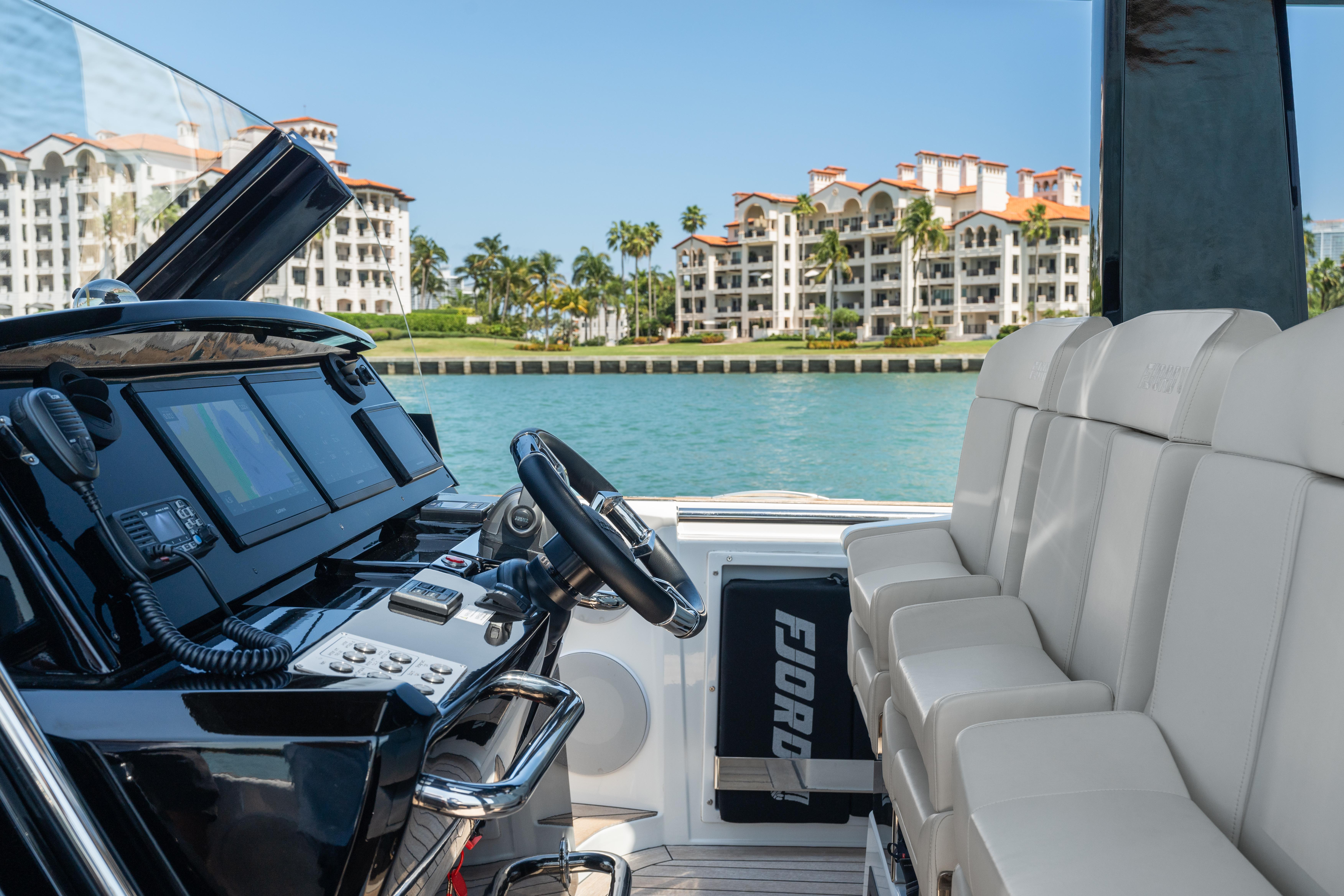 Fjord-44 Open 2022-HINJUICE FL-US-2022 Fjord 44 Open yacht interior with luxury seating and modern dashboard, coastal view in background.-9860902 | Thumbnail