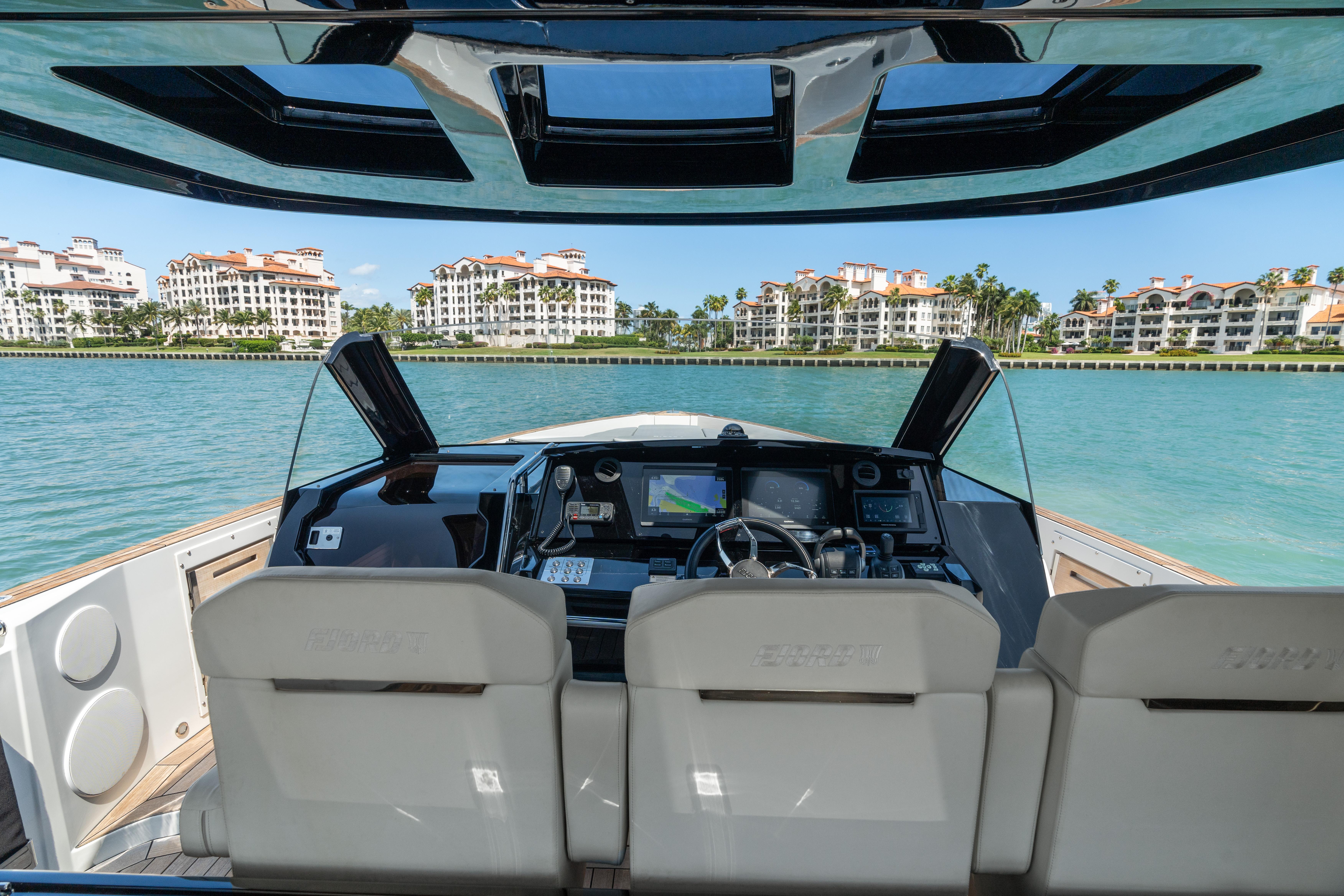 Fjord-44 Open 2022-HINJUICE FL-US-2022 Fjord 44 Open yacht cockpit with modern controls, overlooking waterfront buildings.-9860902 | Thumbnail