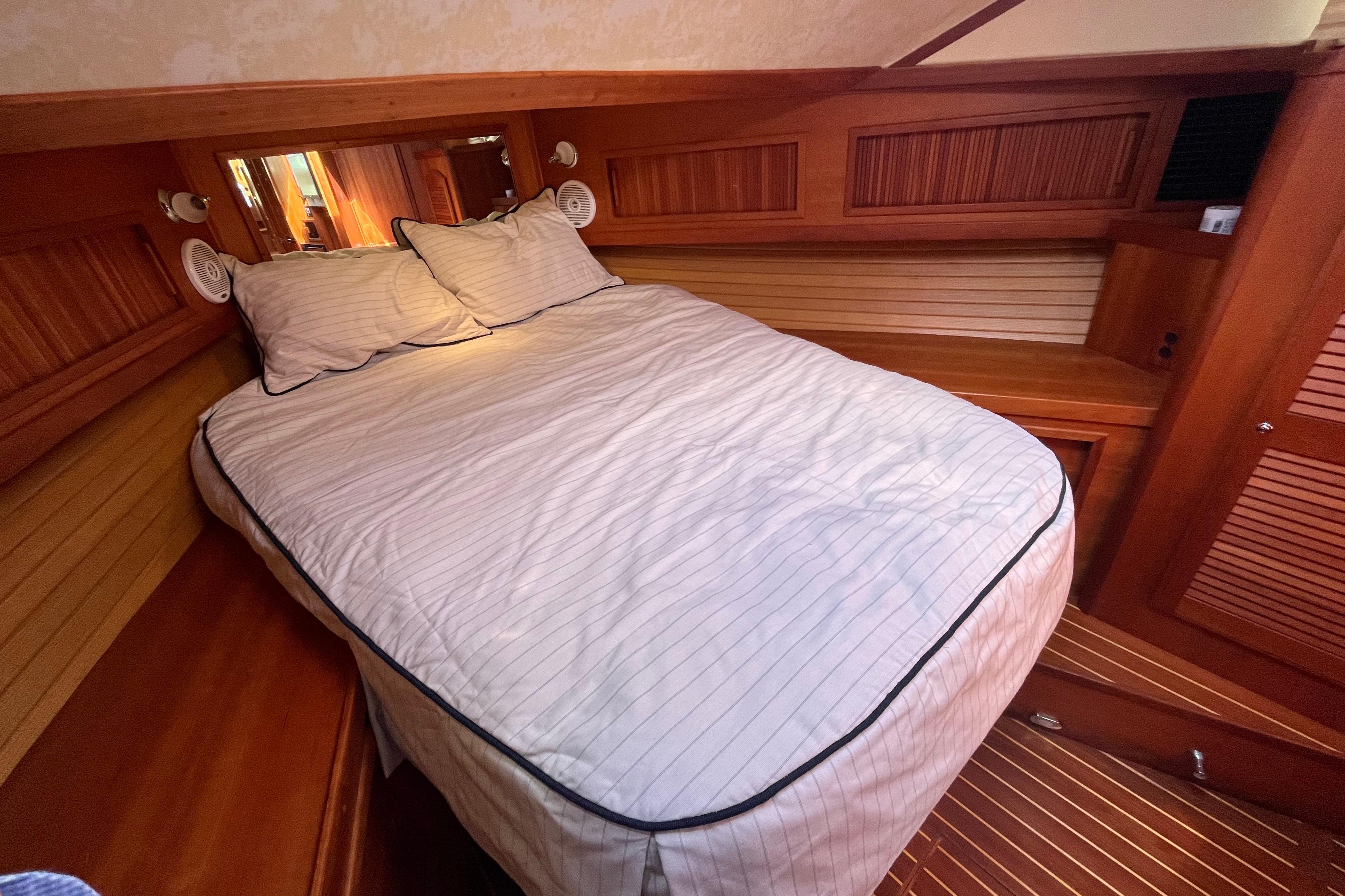 Cozy cabin interior of 2004 Sabre 42 Hardtop Express with wooden accents and comfortable bedding.