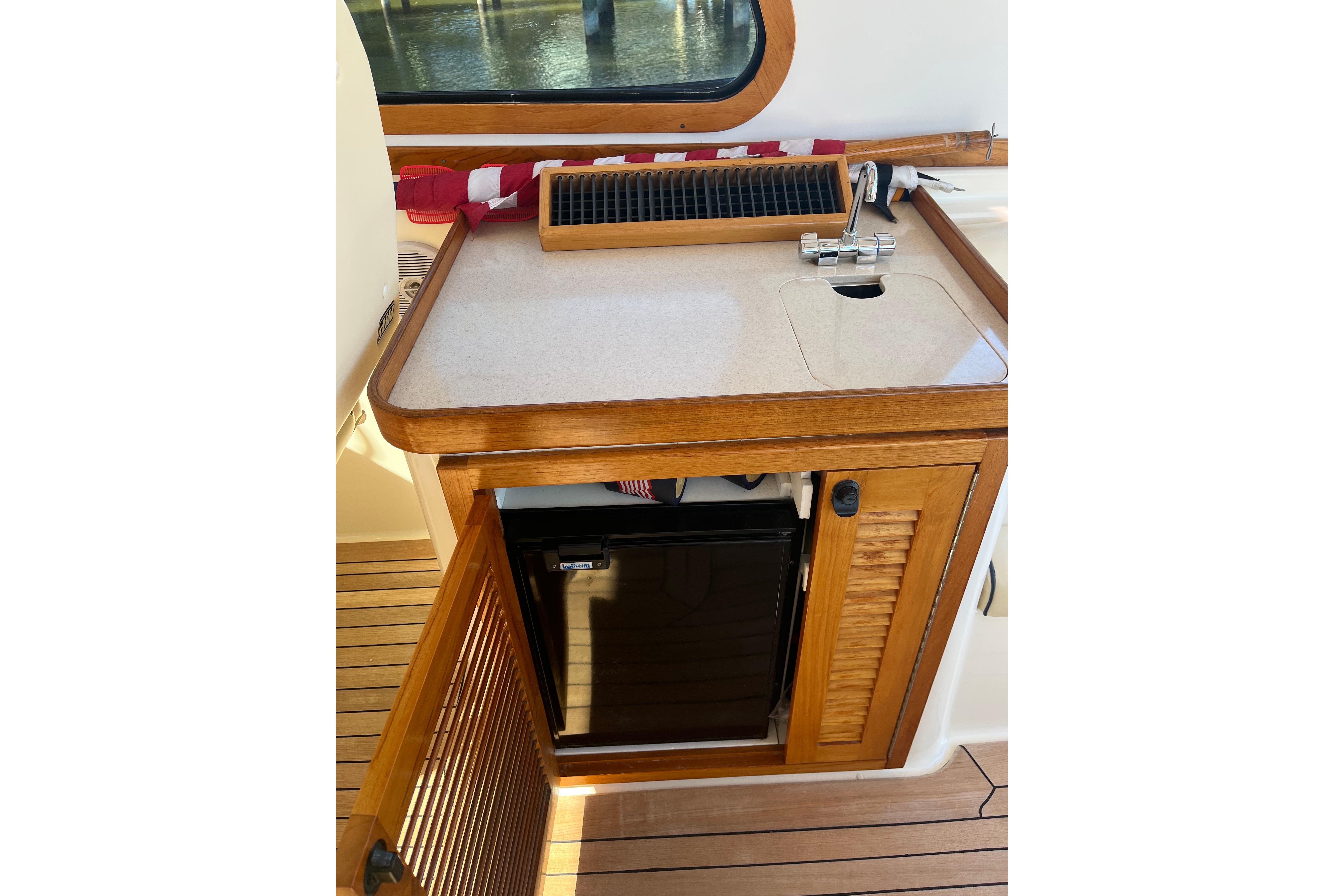 2004 Sabre 42 Hardtop Express interior with wooden cabinetry and mini fridge.