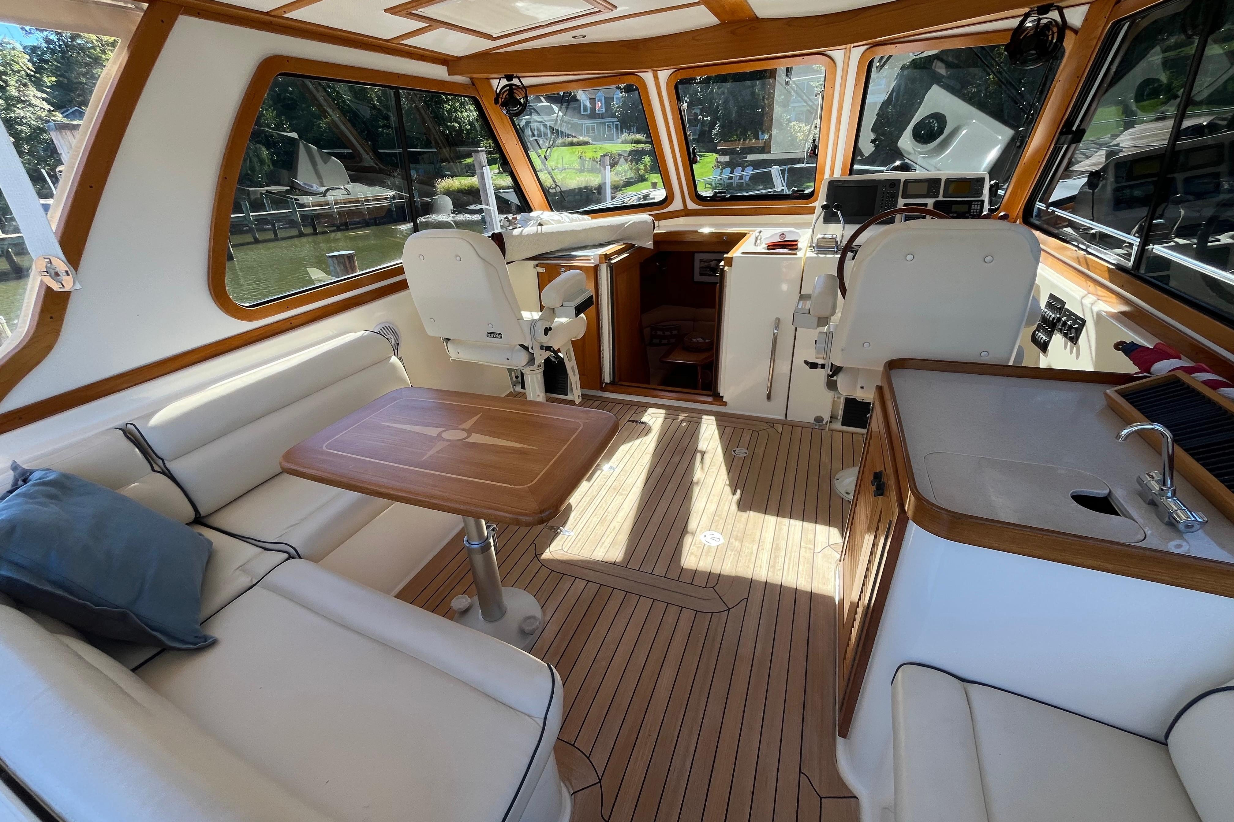 Interior of 2004 Sabre 42 Hardtop Express yacht with seating, table, and helm station.