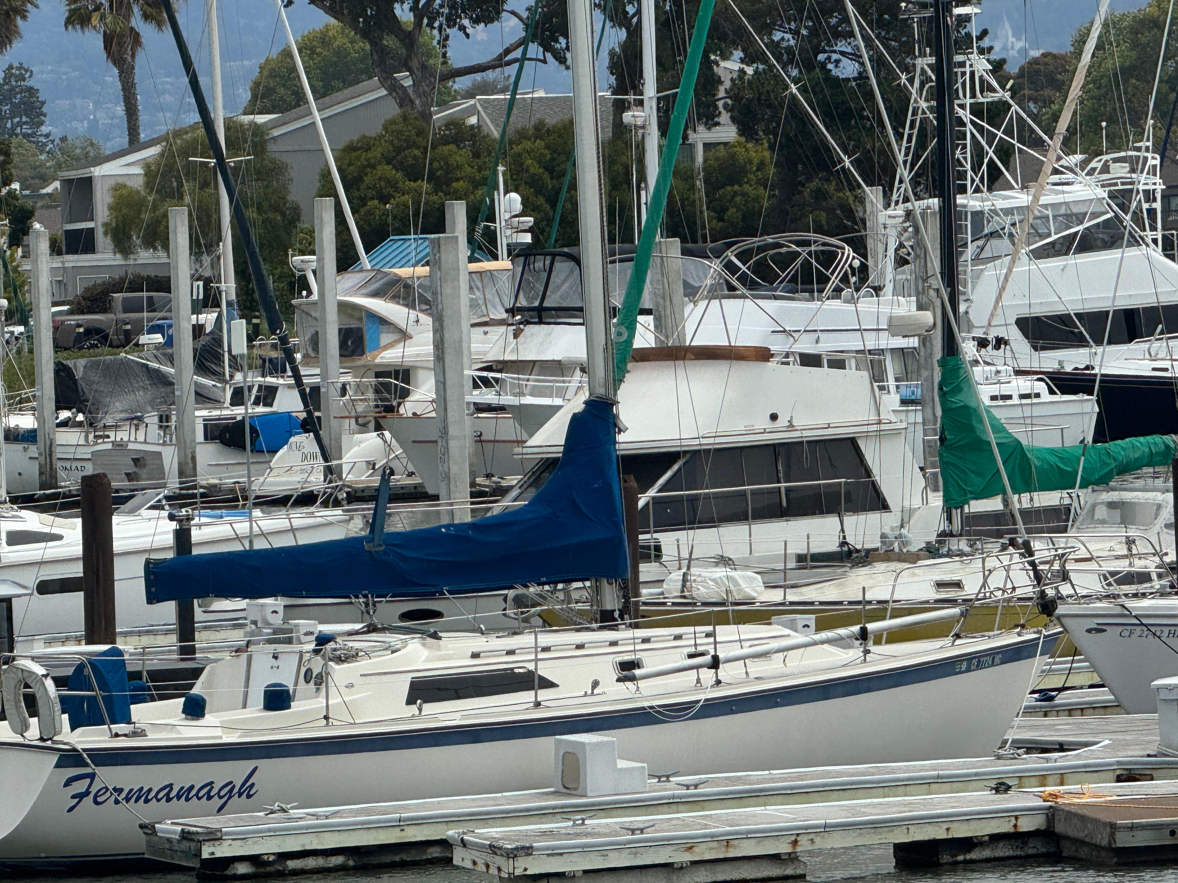 1982 O'Day 34 sailboat docked in a marina, surrounded by other boats.