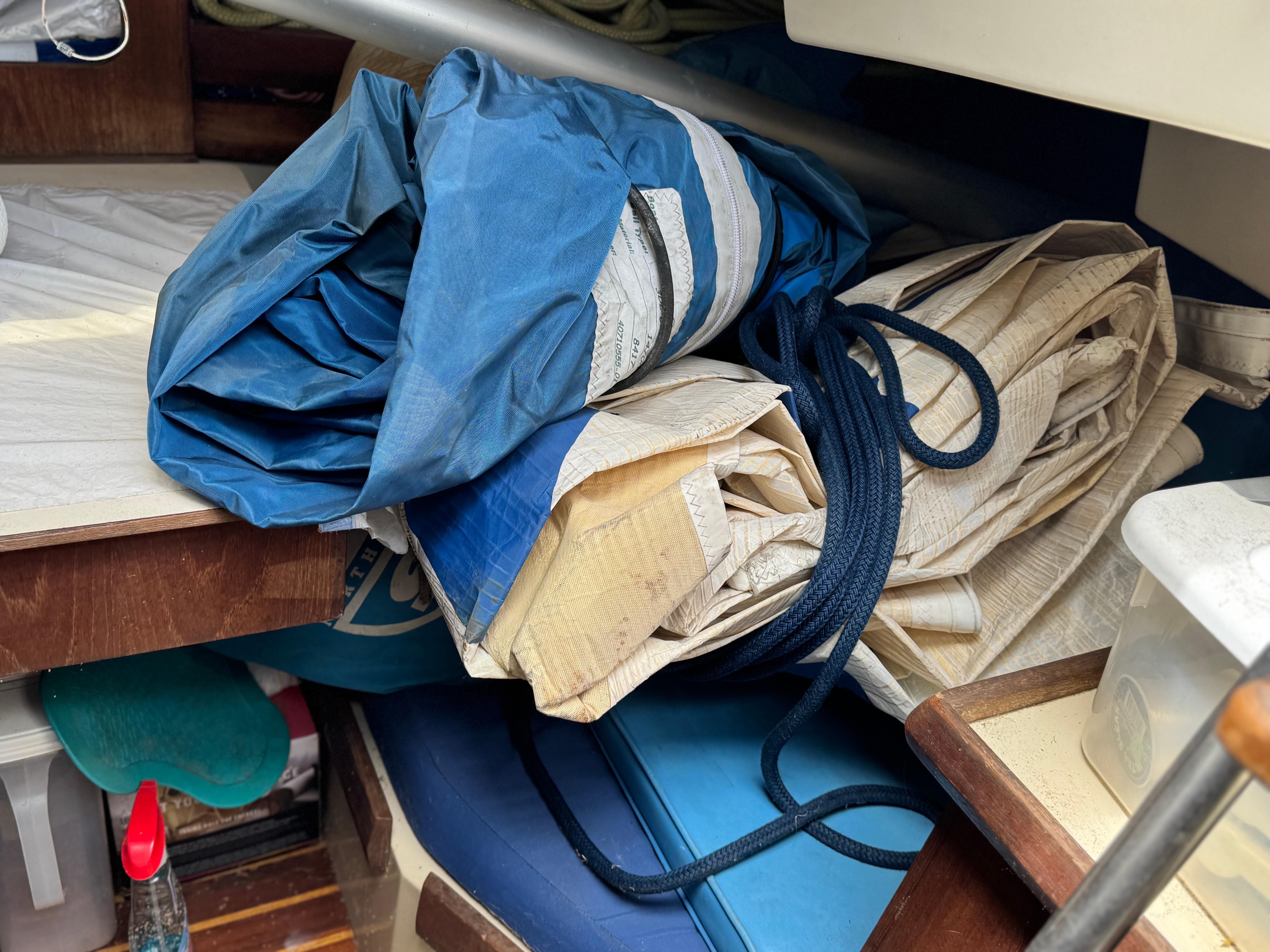 Rolled sails and ropes inside a 1982 O'Day 34 sailboat cabin.