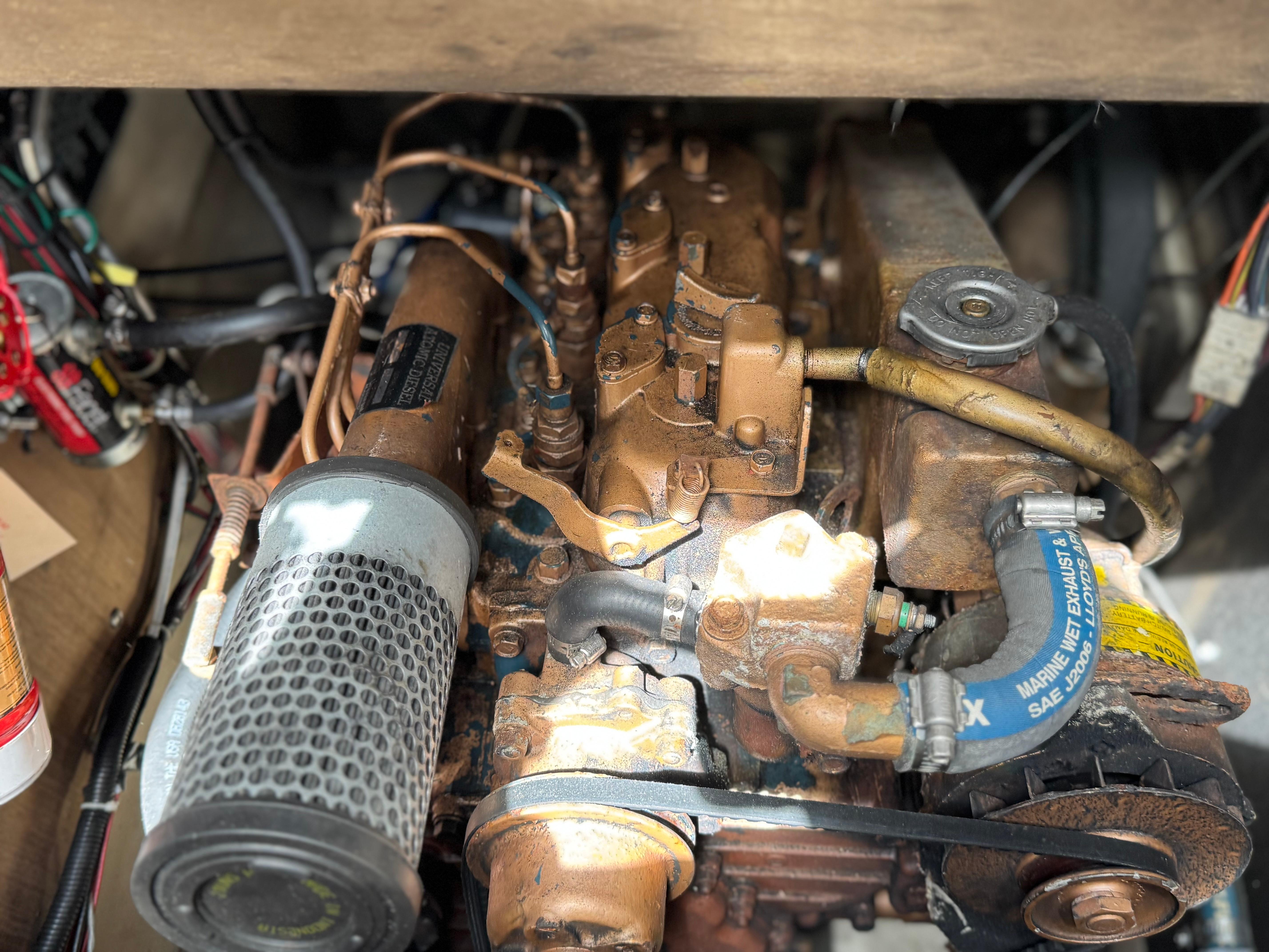 Engine of a 1982 O'Day 34 sailboat, showcasing mechanical components and hoses.