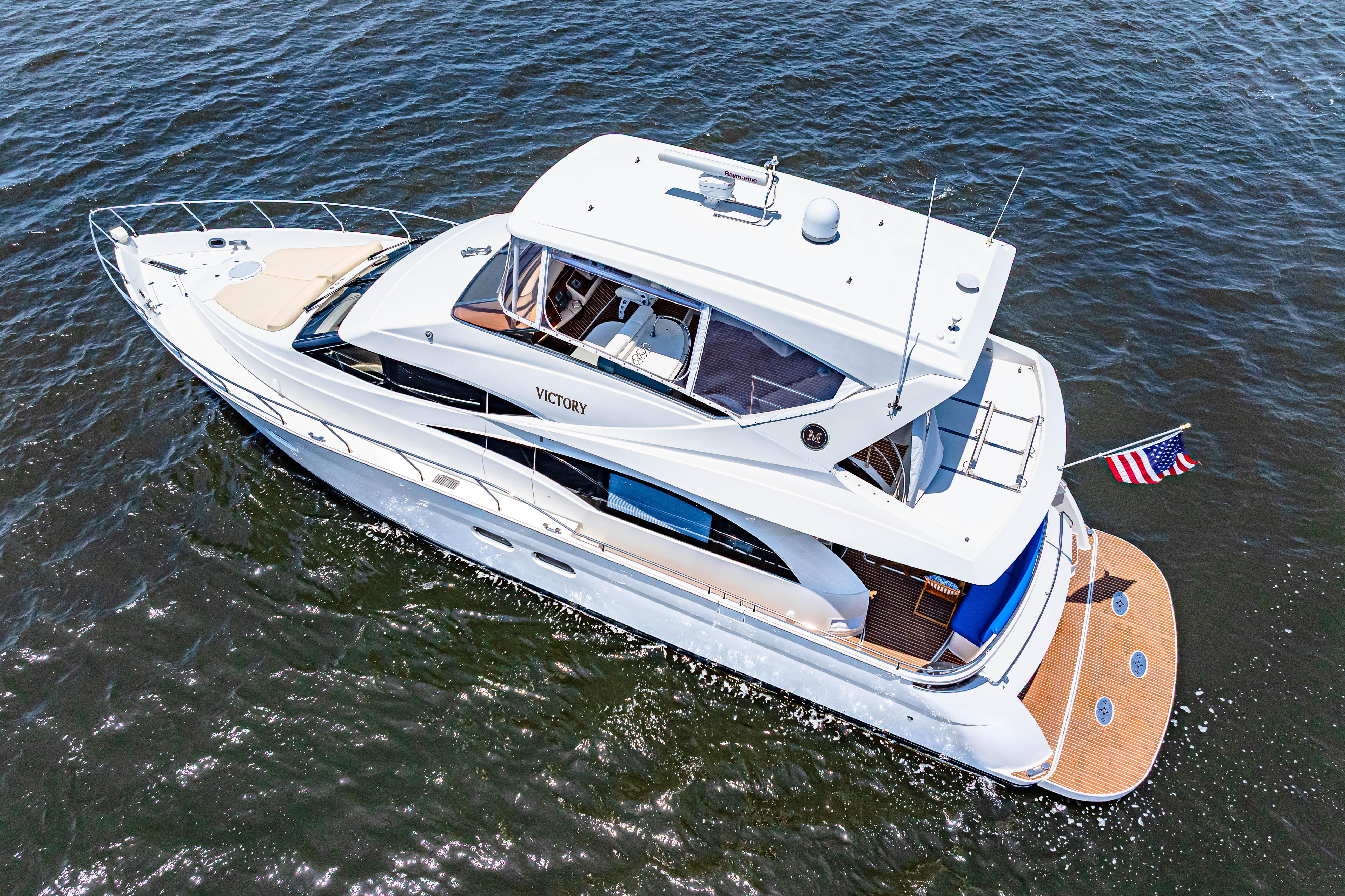 Marquis-59 2005-Victory FL-US-2005 Marquis 59 yacht cruising on open water, featuring sleek design and American flag.-9773566 | Thumbnail