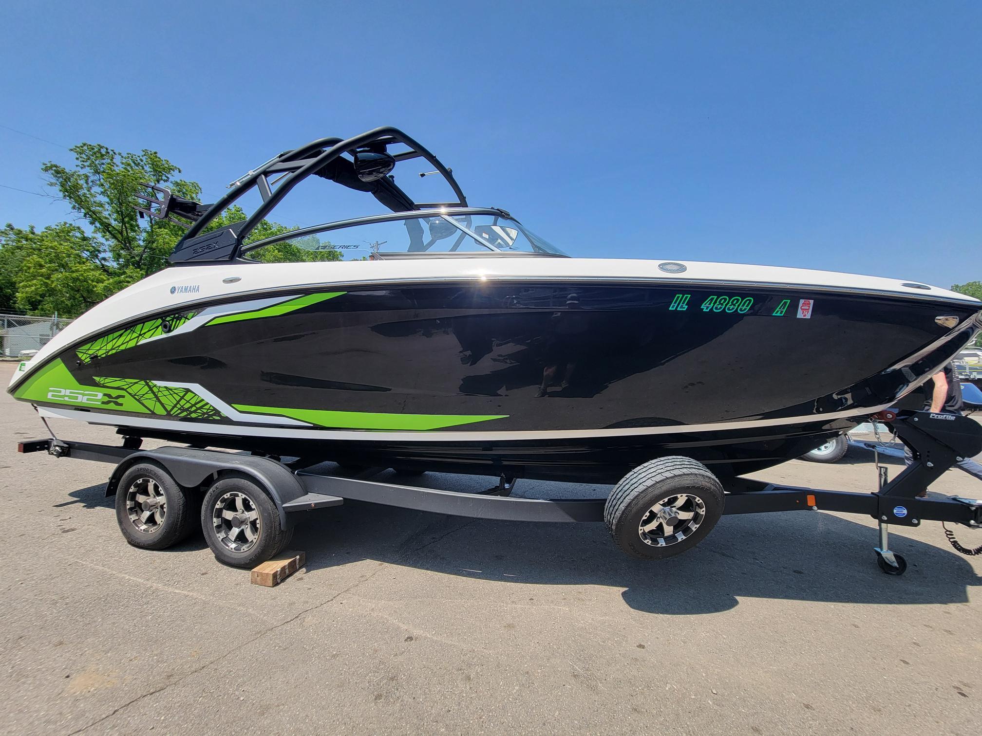 2021 Yamaha Boats 252XE on trailer, black and green design, sunny day.