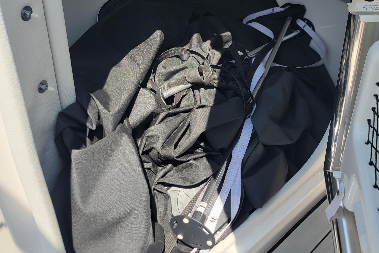 Storage compartment of 2021 Yamaha Boats 252XE with black fabric and pole.